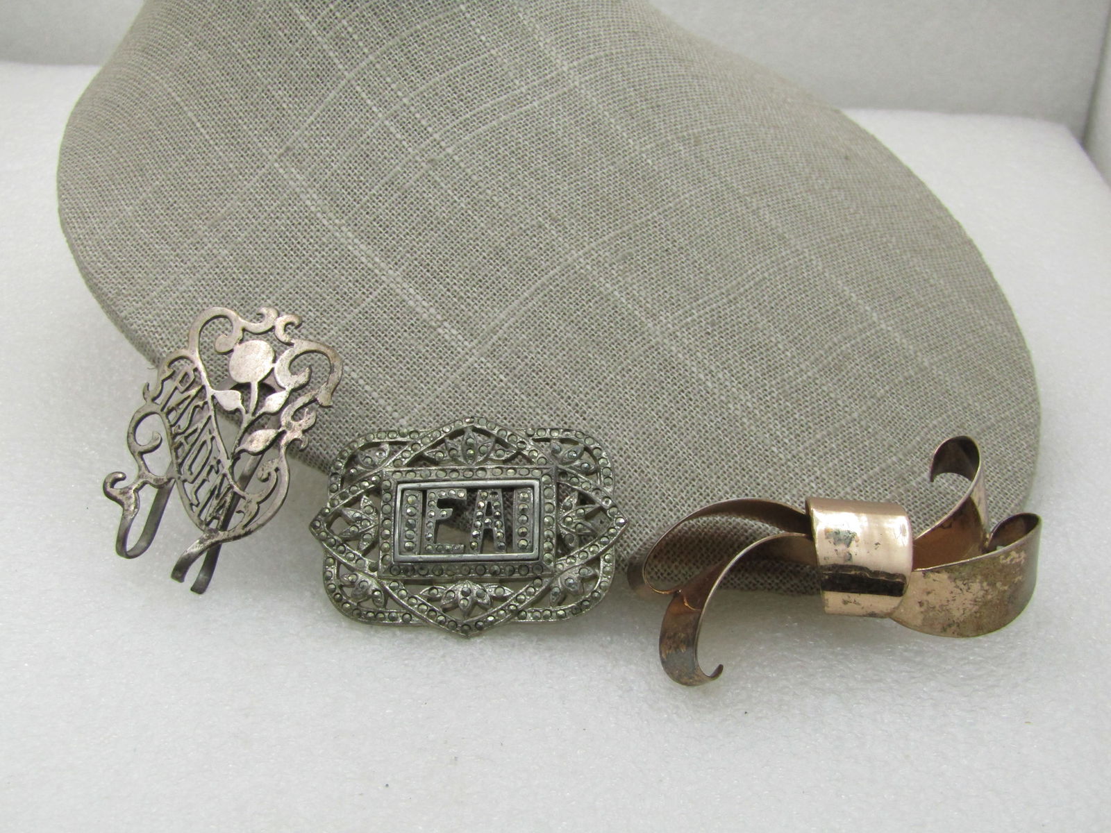 Vintage 3 Sterling Vintage Brooches, Money Clips, Repair or Repurpose, 40.55 Gr.: Vintage 3 Sterling Vintage Brooches, Money Clips, Repair or Repurpose, 40.55 Gr. A Napier gold over sterling modern bow brooch missing the pin back. 1960's, 2.5"; Marcasite sterling brooch with initia