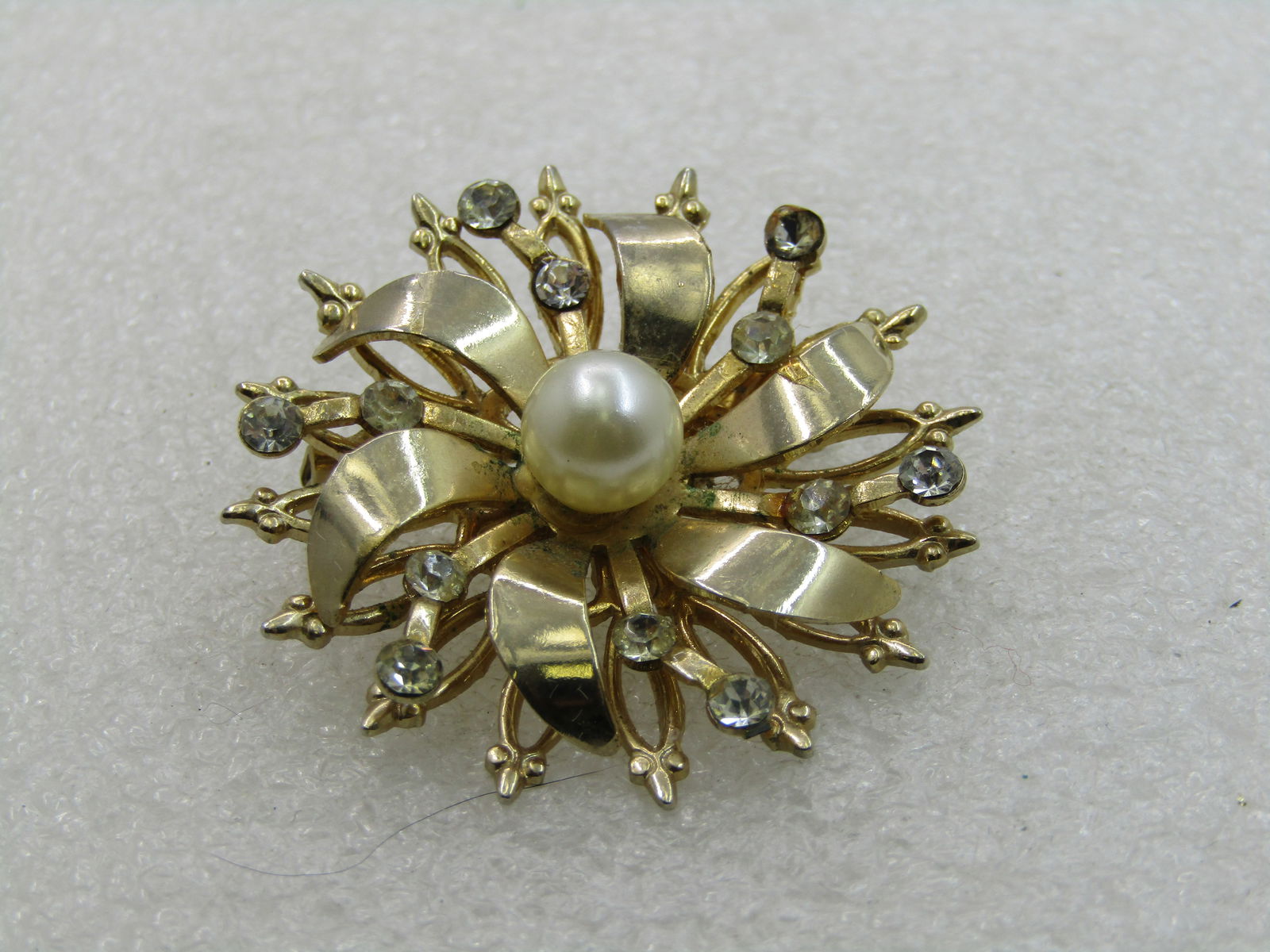 Vintage Rhinestone & Faux Pearl Brooch, Blossom/Snowflake, 1960's: Vintage Rhinestone & Faux Pearl Brooch, Blossom/Snowflake, 1960's. 1.5" across with a center 7.5mm faux pearl and rhinestoines on the second lowest tier. The brooch has a triple tier with the second t