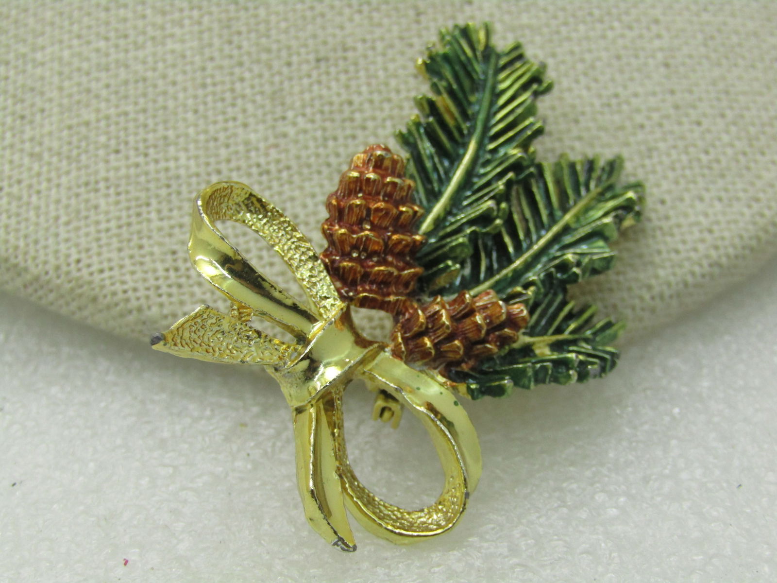 Vintage Gerry's Pine Branch Brooch, Pine Cones & Bow, Enameled 1960's, 2": Vintage Gerry's Pine Branch Brooch, Pine Cones & Bow, Enameled, 1960's, 2" tall, 1.5" wide. The pine cones are enameled in brown with green pine branch. Signed Gerrys, gold tone. Very good condition.