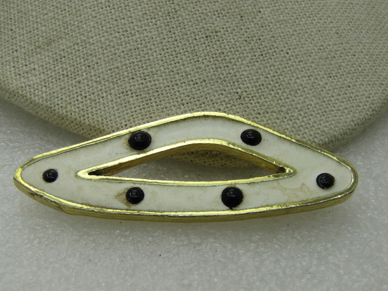 Vintage Enameled Triangular Mod Brooch, Black & White, 2.5", 1980's: Vintage Enameled Triangular Mod Brooch, Black & White, 2.5" by 1", 1980's. Enameled in white with raised round graduated size black bead-like accents. Open in the center. Gold tone, not signed by the
