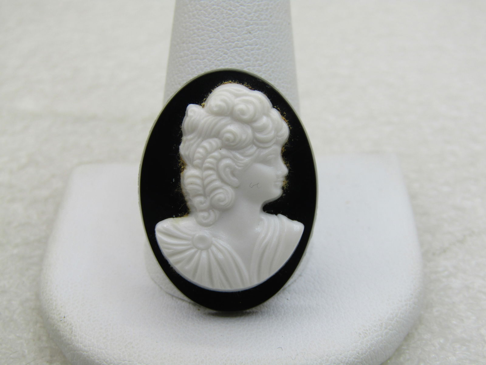 Vintage Black & White Cameo Brooch, Plastic, 1", 1960s NL: Vintage Black & White Cameo Brooch, Plastic, 1", 1960s NL. Appx. 3/4" wide, pressed white plastic cameo sitting on a black background. Very good condition. Not signed by the maker. (INV. W. 8.1118.2,