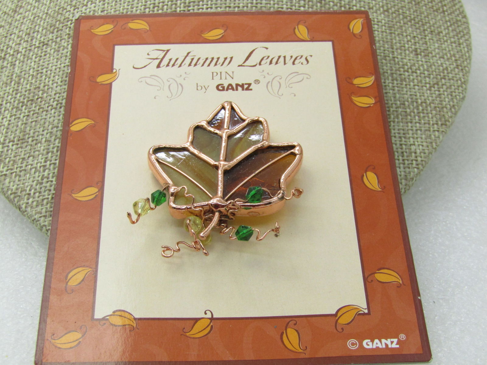Vintage Autumn Leaves Stained Glass Brooch, by Ganz, Vintage New on Card: Vintage Autumn Leaves Stained Glass Brooch, by Ganz, Vintage New on Card. Copper tone framing and details with curls and green and pale yellow beads. 2" by 1.5". Great for September through Thanksgivi
