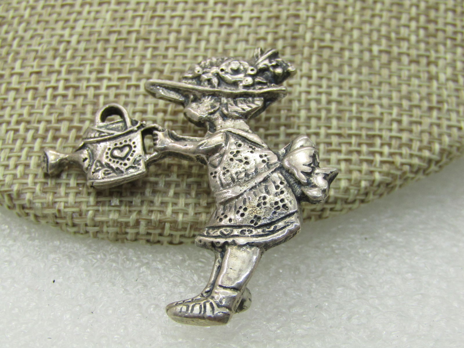 Vintage Sterling Mary Engelbreit Girl Watering Flowers Brooch, signed ME INK: Vintage Sterling Mary Engelbreit Girl Watering Flowers Brooch, signed ME INK, 888 grams. 1.5" tall and appx. The same wide. Stamped details on the girl. 1990's. Very good condition. (INV.WCOV.1X1 SS17