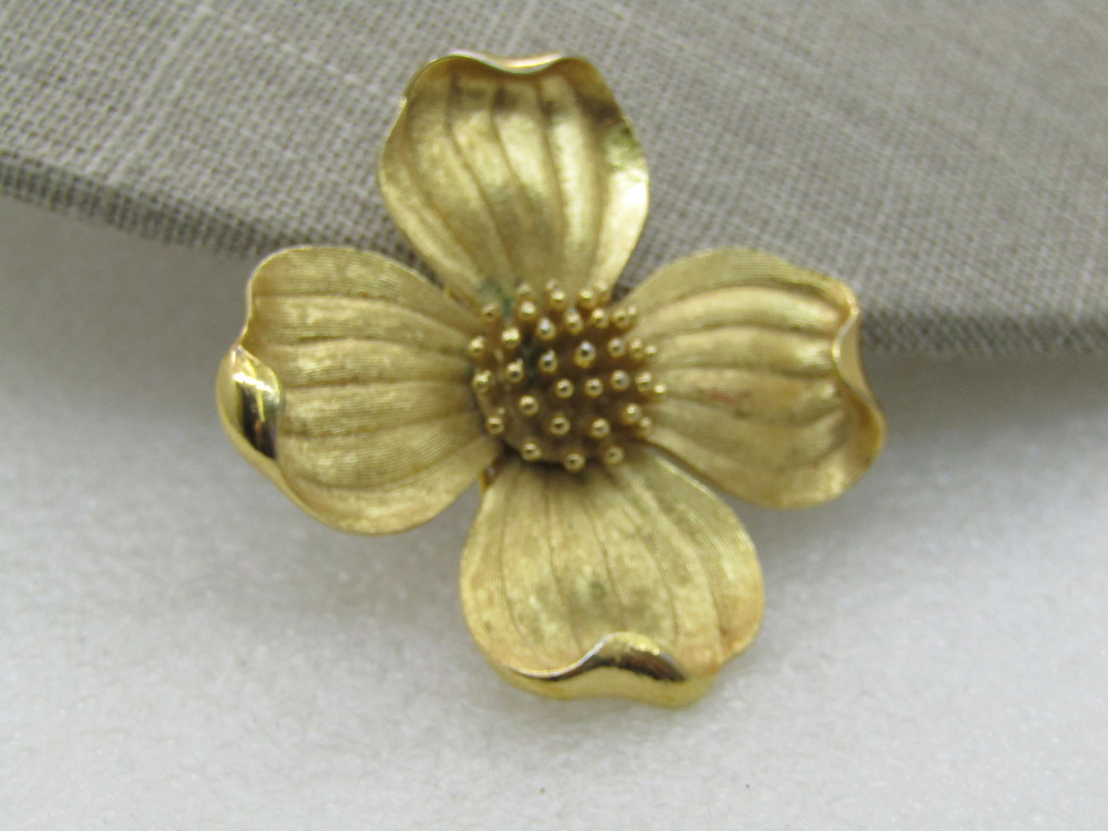 Vintage Trifari Dogwood Brooch, Gold Tone, 1970's: Vintage Trifari Dogwood Brooch, Gold Tone, 1970's. 1.75" across with textured petals and raised gold tone beaded center. Very good condition. (INV. W.102016. SS3475 J LD 1/20/21). Reserve: $30.00 Ship