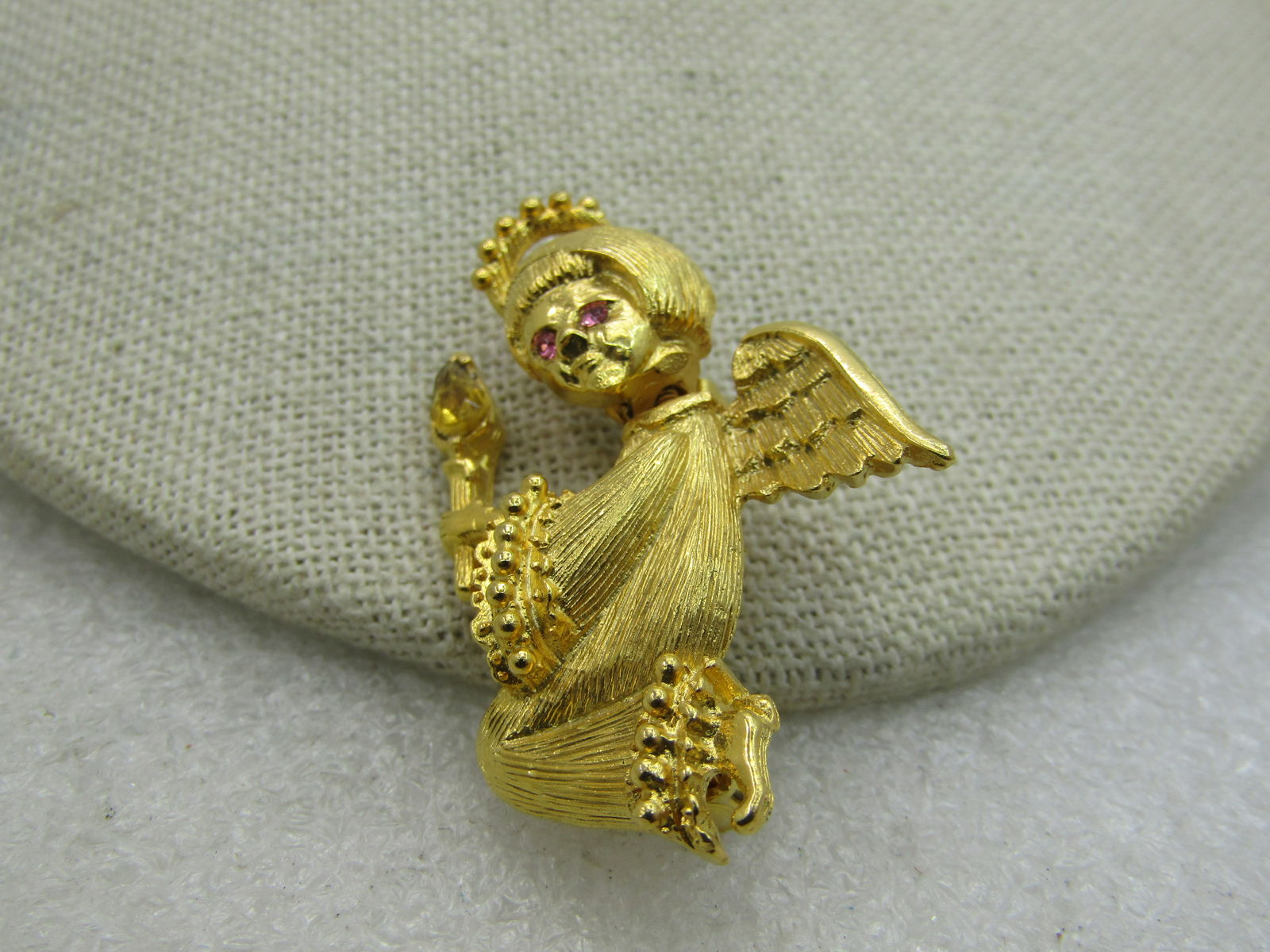 Vintage Gold Crown Rinestone Angel Trembler Brooch, 1.75": Vintage Gold Crown Rinestone Angel Trembler Brooch, 1.75" tall and 1.25" wide. Pink rhinestones eyes and a gold rhinestone at the candle tip for the flame. Kneeling position. Signed Gold Crown behind