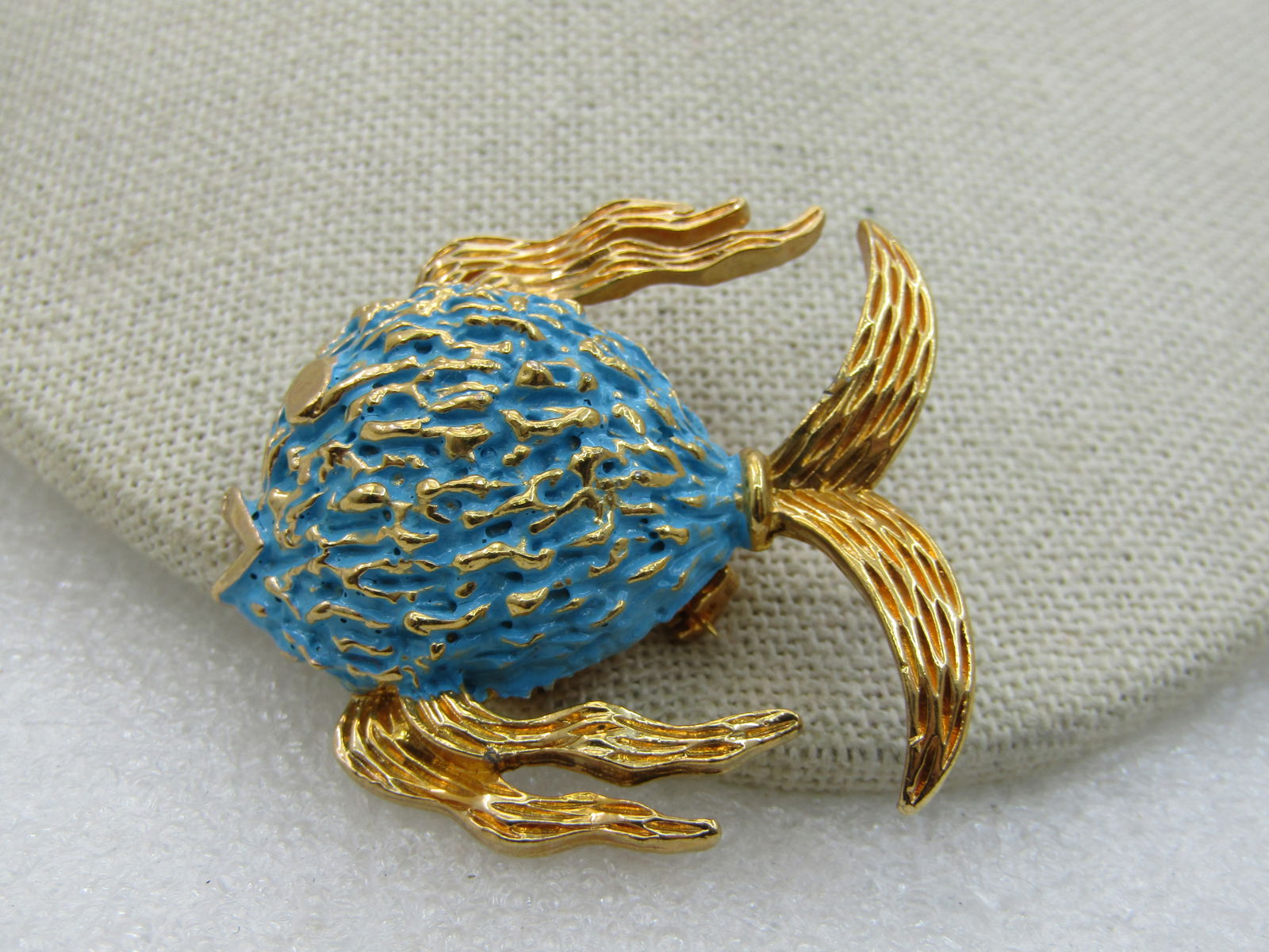 Vintage Blue Enameled Tropical Fish Brooch, Gold Tone, 1960's-1970's: Vintage Blue Enameled Tropical Fish Brooch, Gold Tone, 1960's-1970's. Textured finish with a teal or aqua enameld body and gold highlights on the body of the fish and flowing textured fins and a v-sha