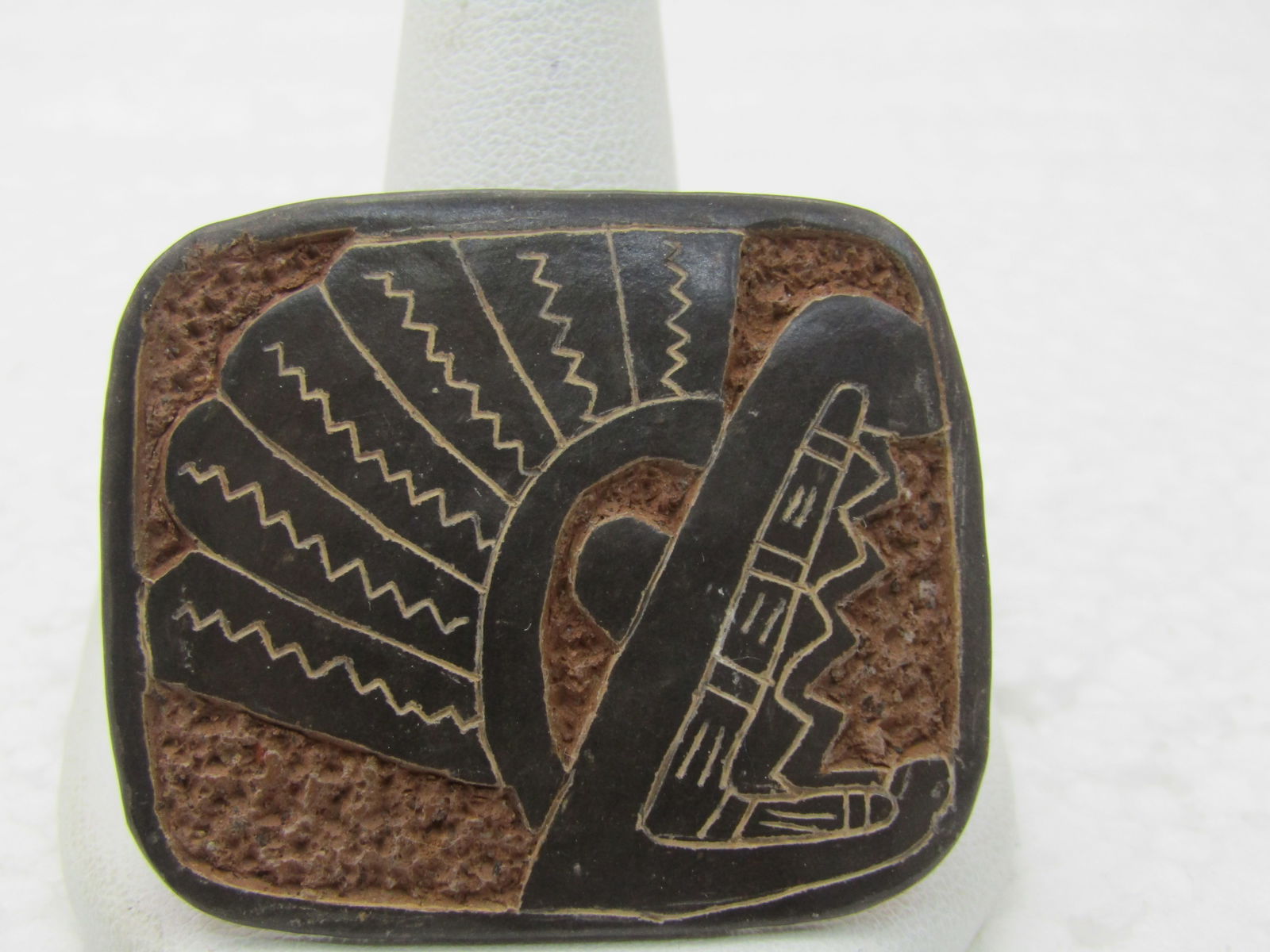 Vintage Southwestern Native American Carved Brooch, 1-5/8: Vintage Southwestern Native American Carved Brooch, 1-5/8 by 1-3/8. Seems to be a clay substance that has dark terracota textured background with a raised dark brown feather or headdress design with a