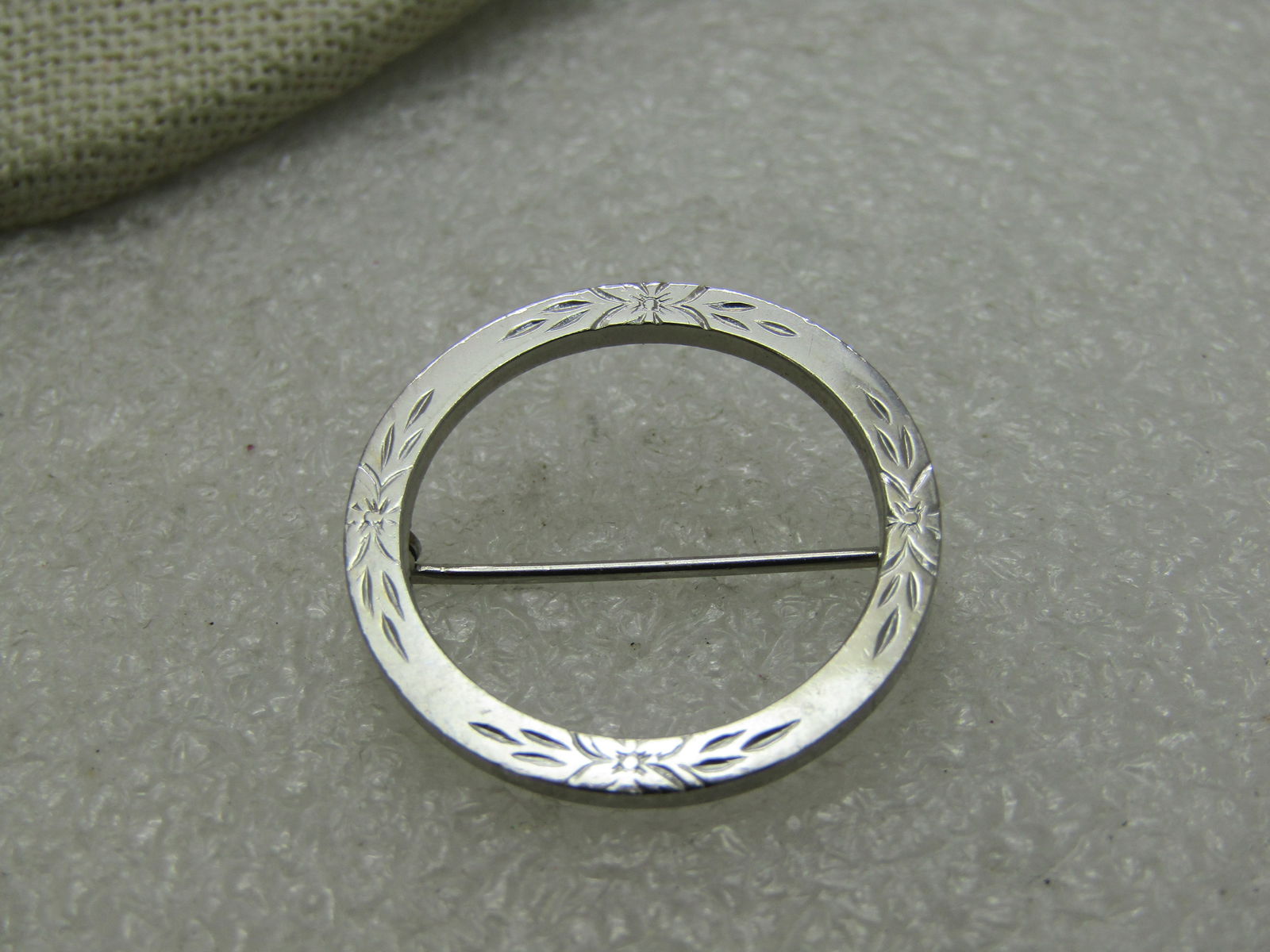 Vintage Floral Silver Plated Circle Brooch, 1". 1970's: Vintage Floral Silver Plated Circle Brooch, 1" 1970's. Etched floral design in four areas spaced equally around the brooch. Not marked or signed but tests as silver plated. Very good condition. (INV.