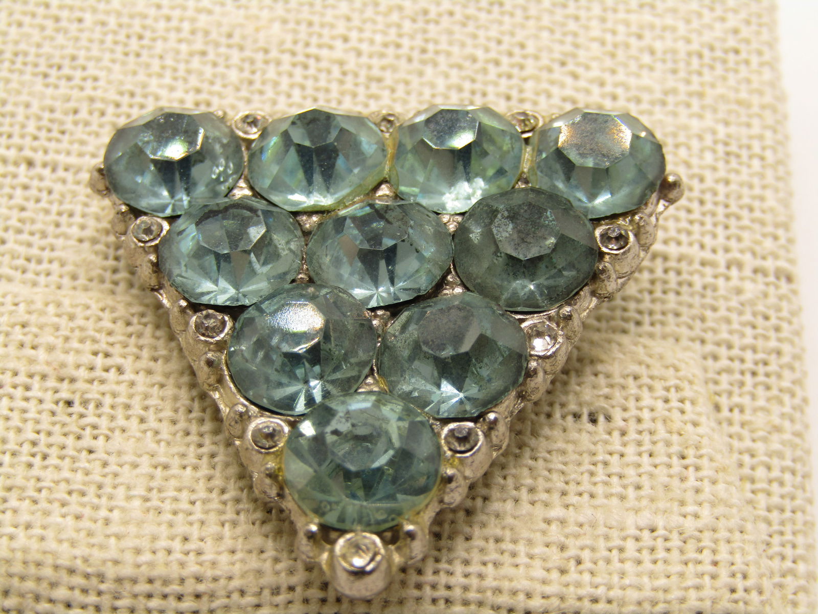 Vintage 1920's Blue & Clear Rhinestone Brooch, Triangular, 1.5": Vintage 1920's Blue & Clear Rhinestone Brooch, Triangular, 1.5" down each side. The aqua blue rhinestones are appx. 8mm wide with smaller clear rhinestones scattered betwwen the stones on the outer fr
