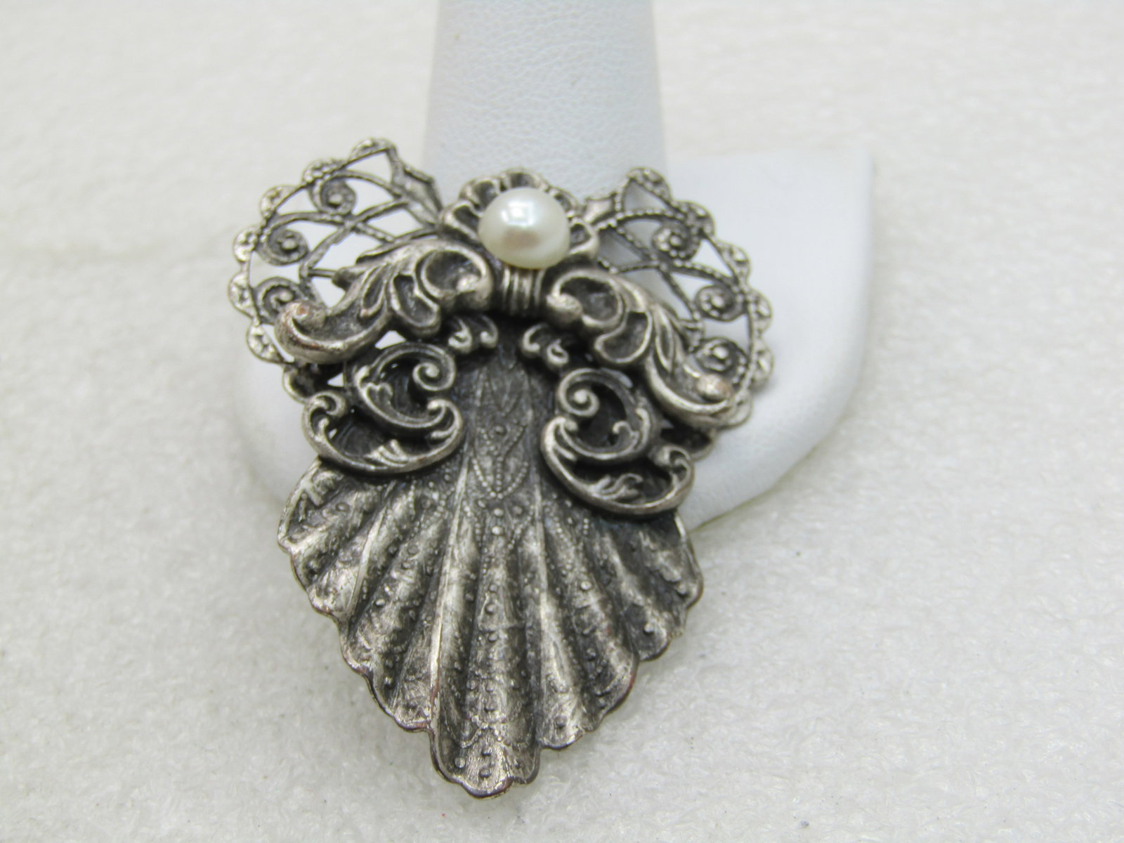 Vintage 1997 Jane Victorian Angel Brooch, 2": Vintage 1997 Jane Victorian Angel Brooch, 2" tall and 1-5/8" wide. Silver Tone, 6.5mm faux pearl cabochone head with filigree wings and Victorian themed design with scrolled accents for arms and stamp