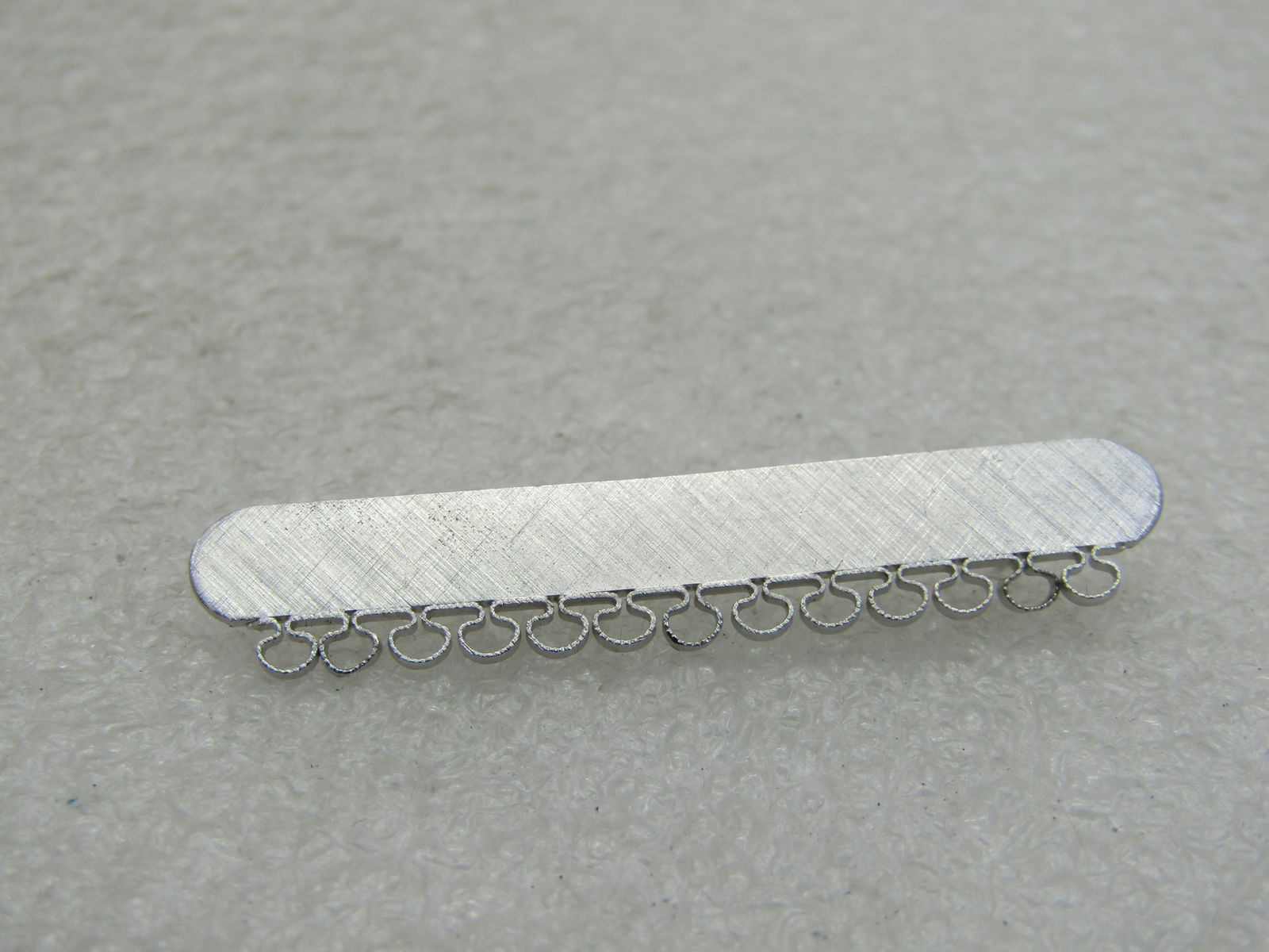 Vintage Sterling Bar Brooch, Can Add Charms, 1-7/8", 3,11 Grams NL: Vintage Sterling Bar Brooch, Can Add Charms, 1-7/8", 3,11 Grams. This is txtured finish with loops that hang from the bottom where charms can be added. 3/8" wide. Very good condition. 1960's. (INV. W.