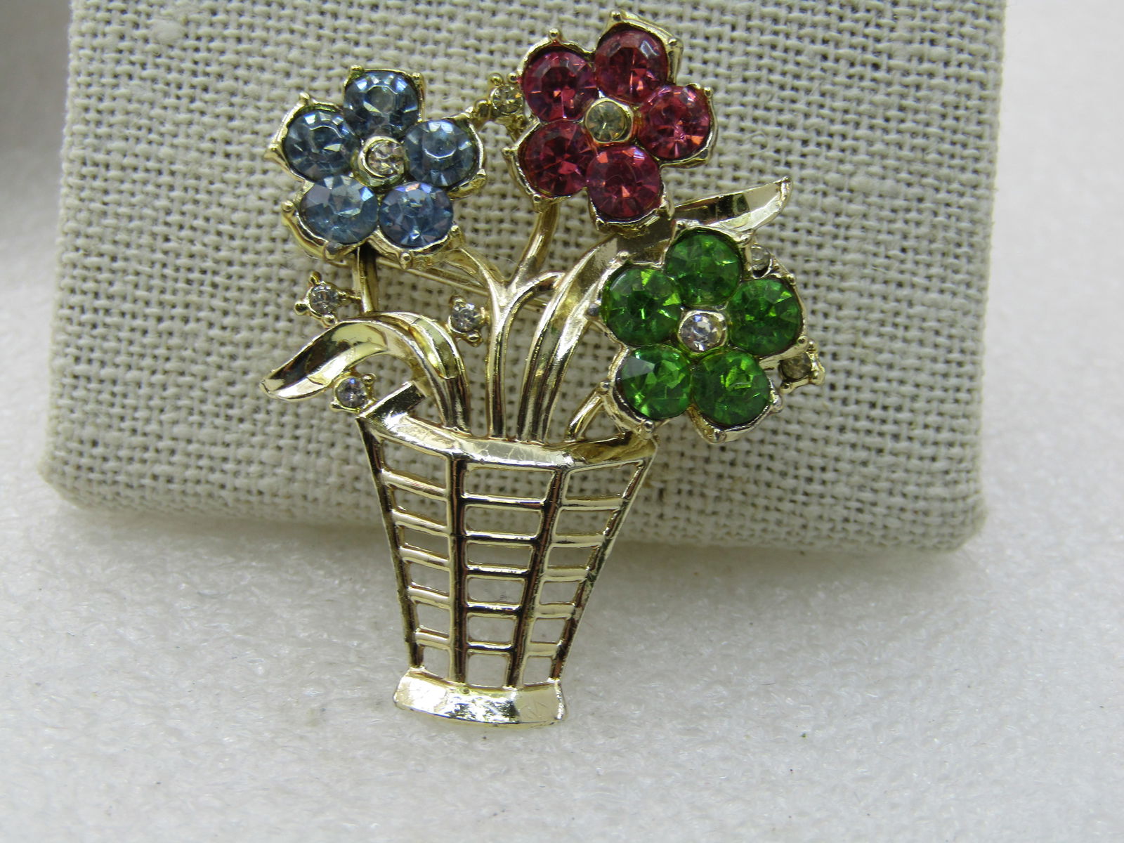 Vintage Rhinestone Floral Basket Brooch, 1.75" Tall, Gold Tone: Vintage Rhinestone Floral Basket Brooch, 1.75" Tall, Gold Tone with blue, pink, and green blossoms with clear centers. Glass or crystal round rhinestones make up each blossom with a few small clear