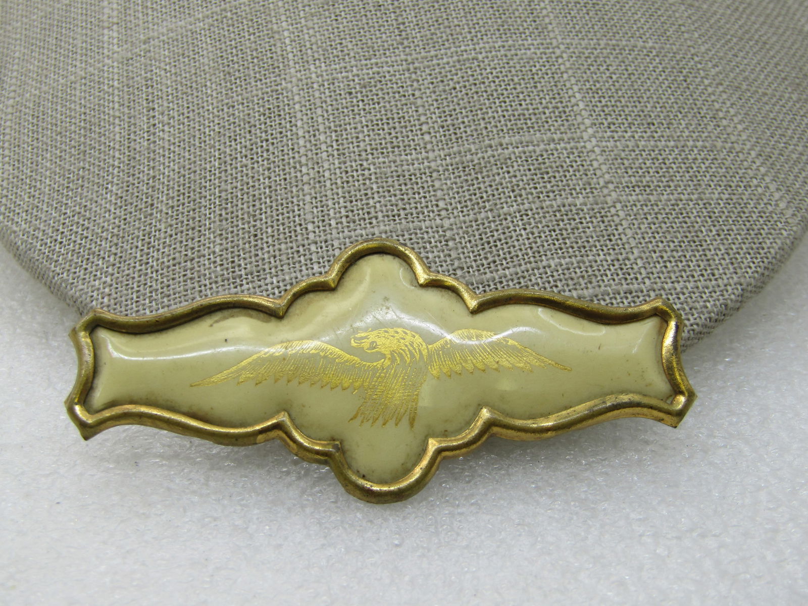 Victorian Eagle Banner Brooch, C-Clasp, 2.75" , 1890's: Victorian Eagle Banner Brooch, C-Clasp, 2.75" wide and 1.25 tall. This is a white puffy enameled type background with a gold eagle outline - likely a transferred piece by decal. The shape of the brass