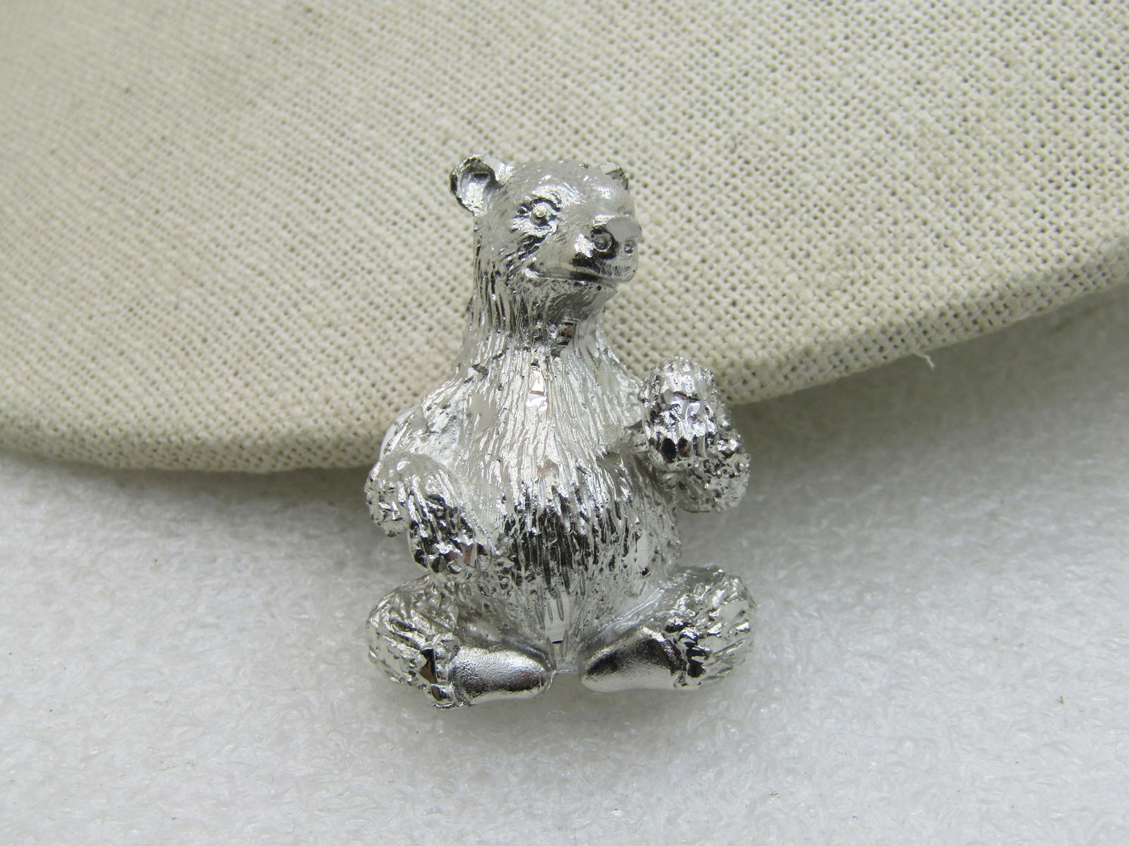 Vintage Sitting Bear Brooch, Silver Tone, 1.5": Vintage Sitting Bear Brooch, Silver Tone, 1.5", and 1-1/8" wide. Diamond Cut Accents and textured finish with smooth finish on feet and nose. Age is 1980's-1990's. Like new condition. Not signed by th