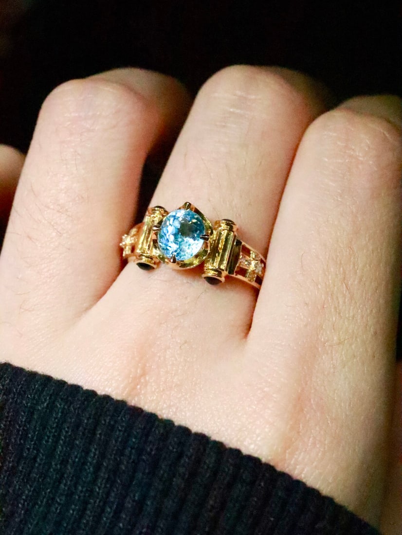 18K Gold Aquamarine Ring with 1.05ct Aquamarine, 0.062ct Diamonds, and 0.28ct Blue Sapphires: Title: 18K Gold Aquamarine Ring with 1.05ct Aquamarine, 0.062ct Diamonds, and 0.28ct Blue Sapphires Description: This lot features an 18K gold ring set with a 1.05ct aquamarine exhibiting bright,