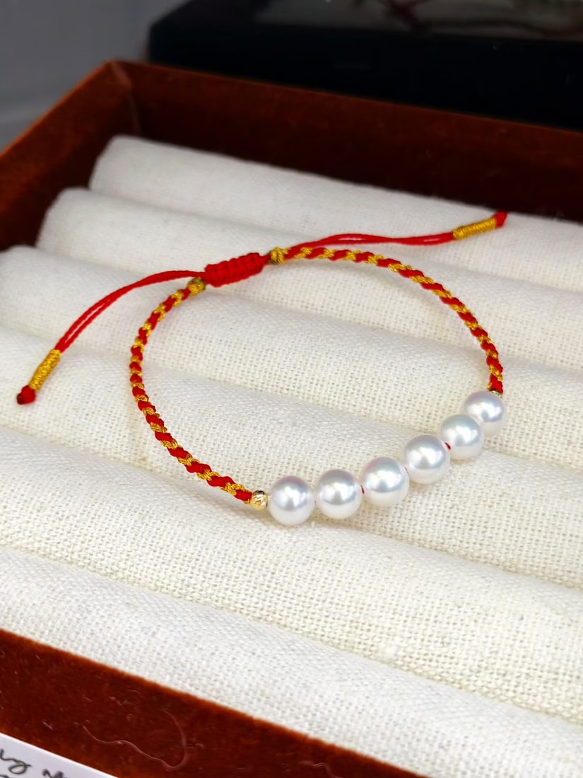 Red Cord Bracelet with 6-7mm Natural Freshwater Pearls: Title: Red Cord Bracelet with 6-7mm Natural Freshwater Pearls Description: Elegant red cord bracelet featuring 6-7mm natural freshwater pearls. Pearls are luminous, well-matched, and near-round. The d