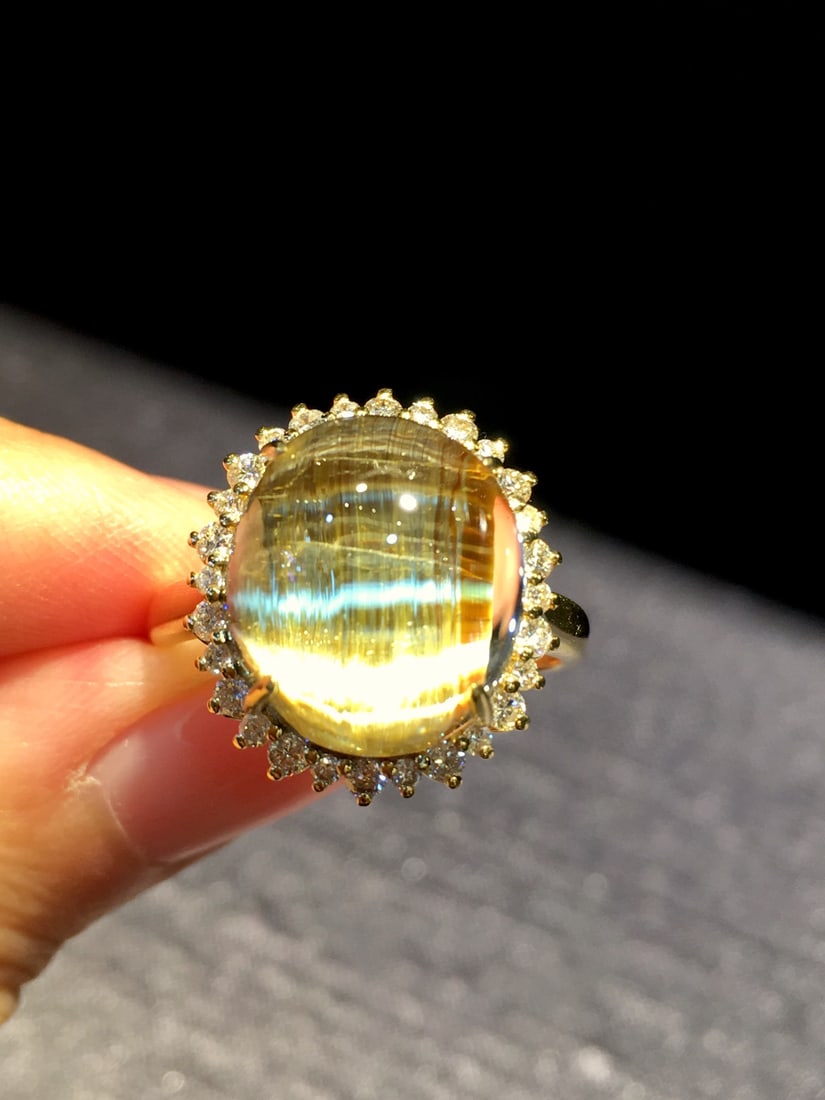 Natural Titanium Crystal Ring with 18K Gold and Diamond Inlay, 17x15mm: Title: Natural Titanium Crystal Ring with 18K Gold and Diamond Inlay, 17x15mm Description: Elegant ring featuring a natural titanium crystal with strong cat's eye effect, set in 18K gold with diamond