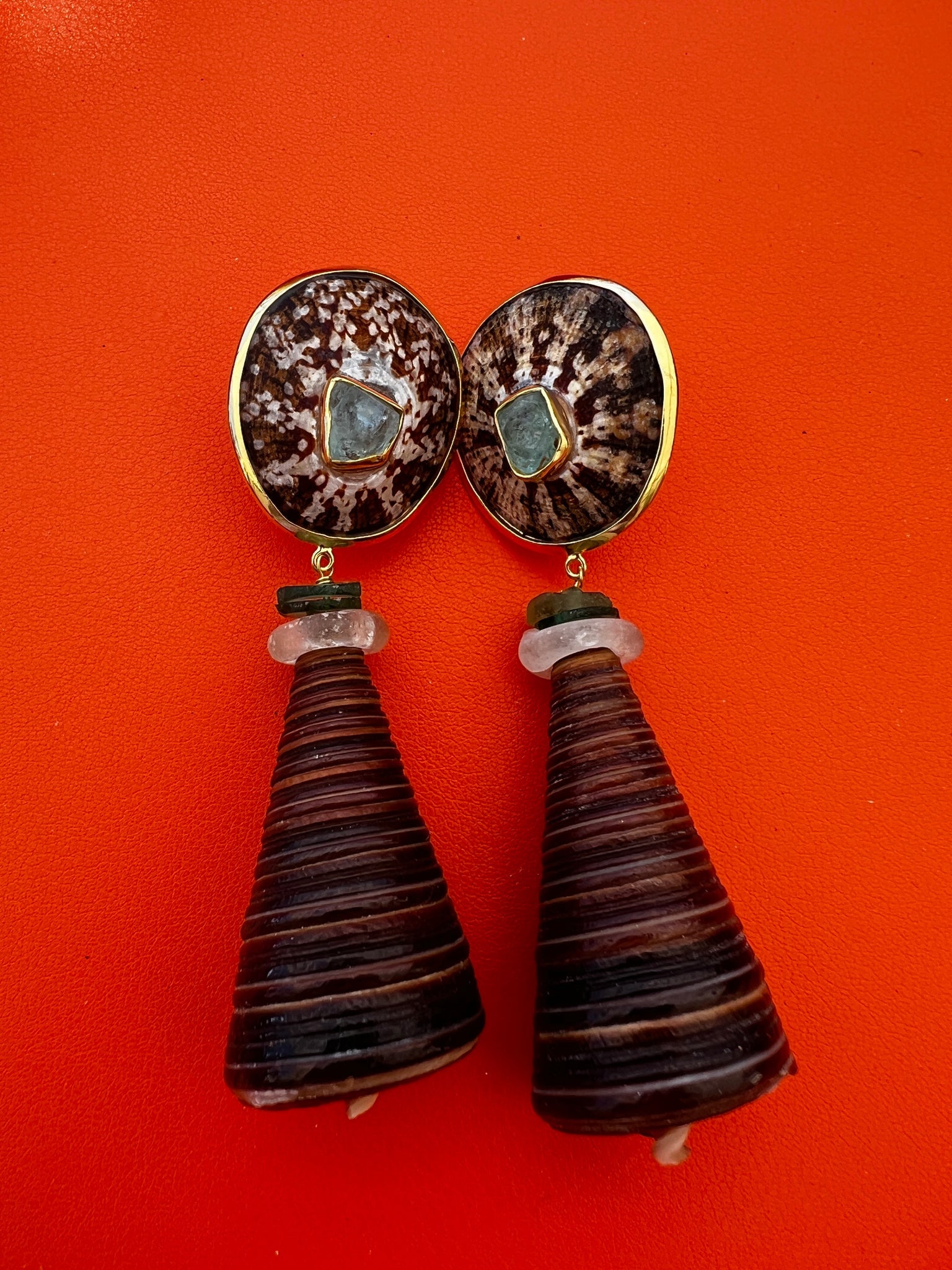 Telescopium Shell Drop Earrings with Tourmalines: Title:Telescopium Shell Drop Earrings with Tourmalines Description:Earthy pair of Limpet-topped earrings set with a raw Paraiba Tourmalines. Dangles of Telescopium shell topped with old African glass