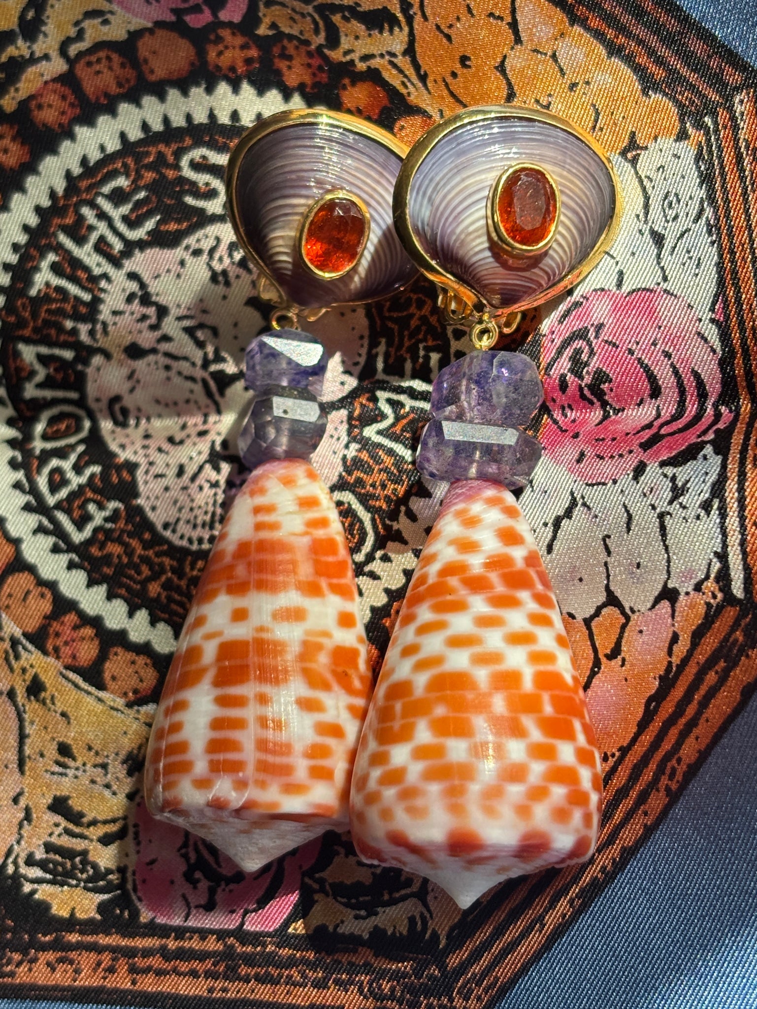 Conus Shell Earrings with Amethyst and Orange Garnets: Title:Conus Shell Earrings with Amethyst and Orange Garnets Description:Pair of outstanding Conus Shell Earrings, dressed up with cool, Included Amethyst and faceted, Orange Garnets - Signed CSS - Ver