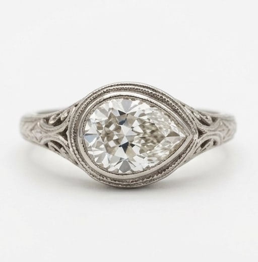 Vintage Bezel Set with Filigree Shoulders Pear Shape 4 ct Lab-Grown Diamond Ring in 14K White Gold: Title: Vintage Bezel Set with Filigree Shoulders Pear Shape 4 ct Lab-Grown Diamond Ring in 14K White Gold Description: This refined vintage bezel set with filigree shoulders ring features a 4 ct lab-g