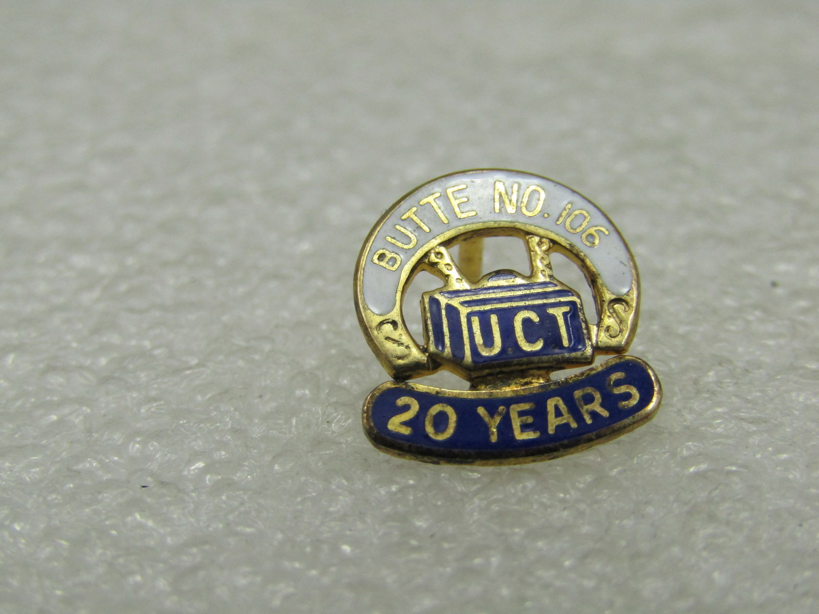 Vintage Sterling UTC Butte No. 106 Year Tack Pin: Vintage Sterling UTC Butte No. 106 Year Tack Pin. Gold over sterling with blue and white enameling. 1.13 gr. Marked sterling and tested. Not signed by the maker. Age is appx. post mid-century. Very go
