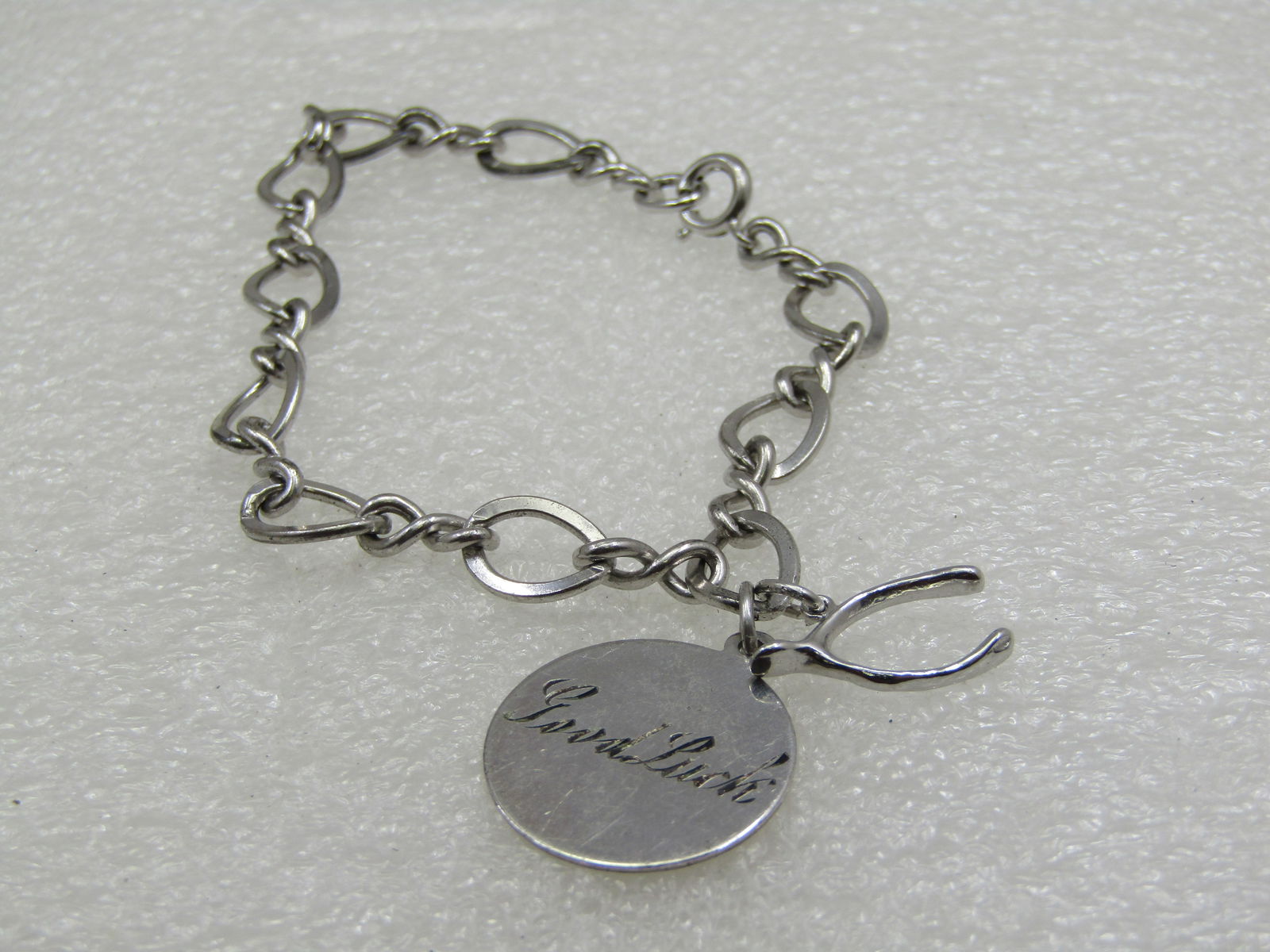Vintage Sterling Silver Charm Bracelet, Wishbone 1960's: Vintage Sterling Silver Charm Bracelet, Wishbone and an engraved Good Luck on one side and R.M & P 4-9-63 on the reverse. Marked sterling and signed Automade. The bracelet is 7.5mm wide with a spring