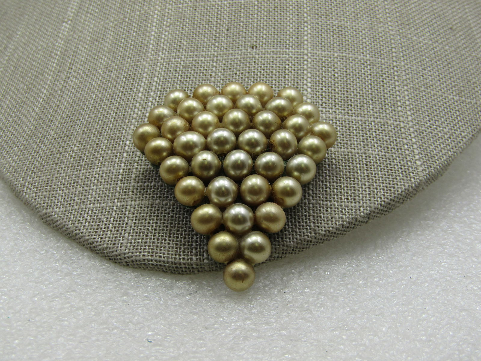 1920's-1930's Faux Pearl Triangular Dress Clip, 2": 1920's-1930's Faux Pearl Triangular Dress Clip, 2". 6mm faux pearls in a silvery champagne luster. Triangular design that is appx. 2" tall. Width is appx. 1-7/8". Tight clasp. Good to very good condit