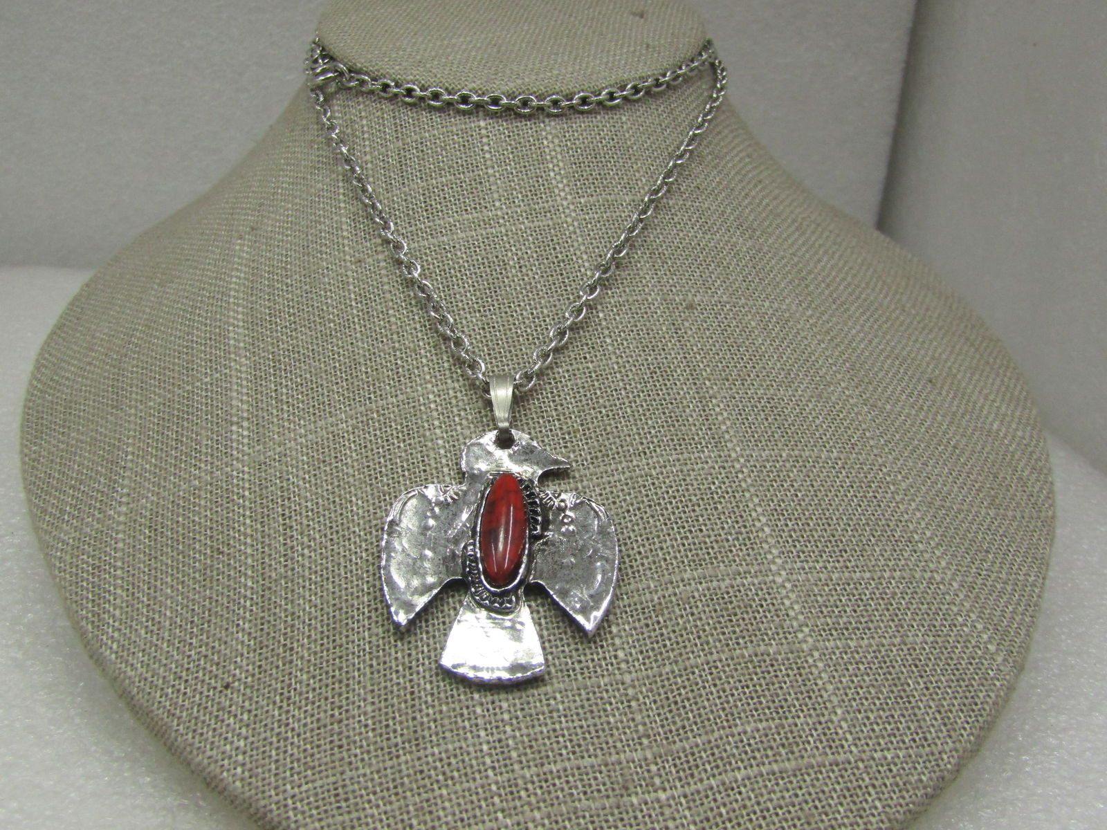 Vintage Costume Southwestern Thunderbird Necklace, 22": Vintage Costume Southwestern Thunderbird Necklace, 22", Silver tone necklace with a 2" thunderbird pendant (including jum pring) and a faux coral stone. The chain is alternating textured oval links, a