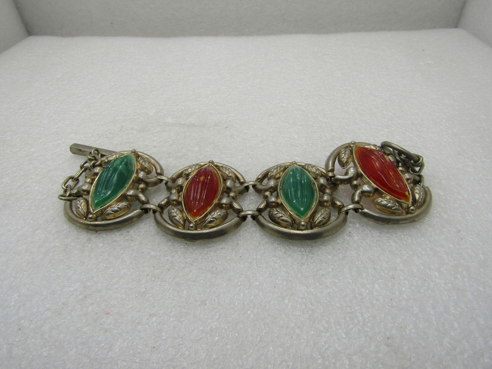 Vintage Runway Statement Bracelet, Green/Amber Ridged Lucite Stones, 8": Vintage Runway Statement Bracelet, Green/Amber Ridged Lucite Stones, 8". Four 1-5.8" links of gold tone leaf-like accents with a cat-eye shaped lucite stone alternating green and amber that are each a