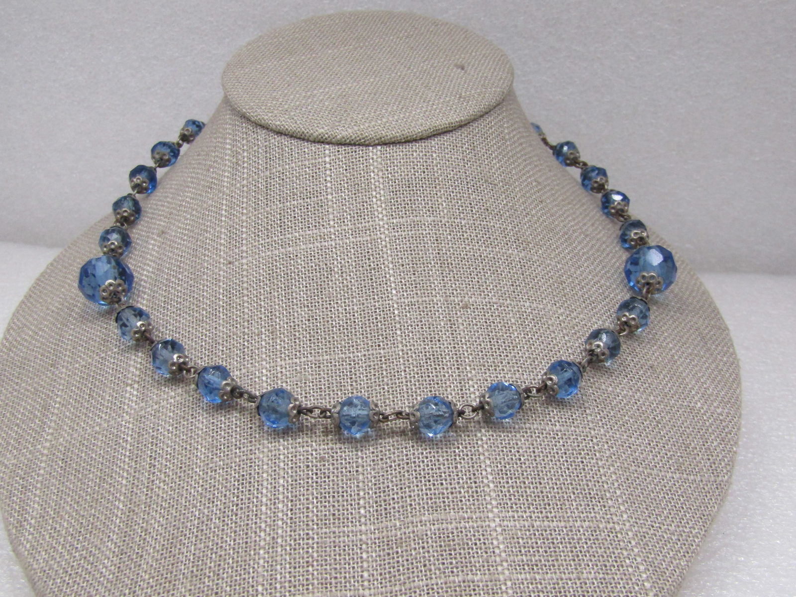Vintage Blue Glass Beaded Necklace, 18", 1940's-1960's: Vintage Blue Glass Beaded Necklace, 18", 1940's-1960's. Beads have silver tone filigree end caps and are mostly 7mm beads and two 12mm beaded, one on each side. Petite hook clasp. Vintage finish wear.