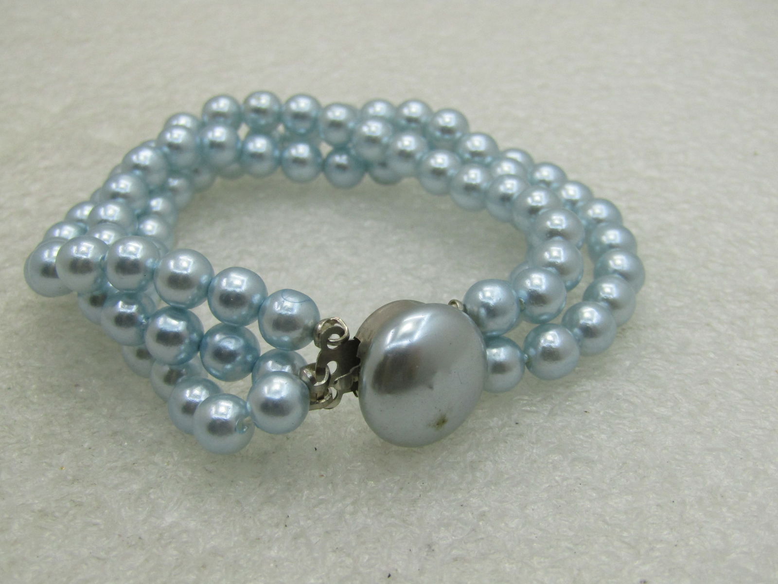 Vintage Baby Blue Faux Pearl Multi-Link Bracelet, 7-1/8", 1950's-1960's: Vintage Baby Blue Faux Pearl Multi-Link Bracelet, 7-1/8", 1950's-1960's silver tone round faux pearl button box clasp with three strands of baby blue shimmering faux pearls that are appx. 5.5mm wide.