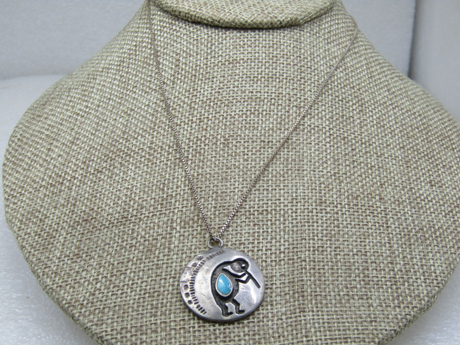 Vintage Sterling Southwestern Turquoise Kokopelli Necklace, 15.5": Vintage Sterling Southwestern Turquoise Kokopelli Necklace, 15.5". The pendant has a recessed kokopelli with an inlaide (raised) turquoise stone and stamped design on the left side, hammered look on f