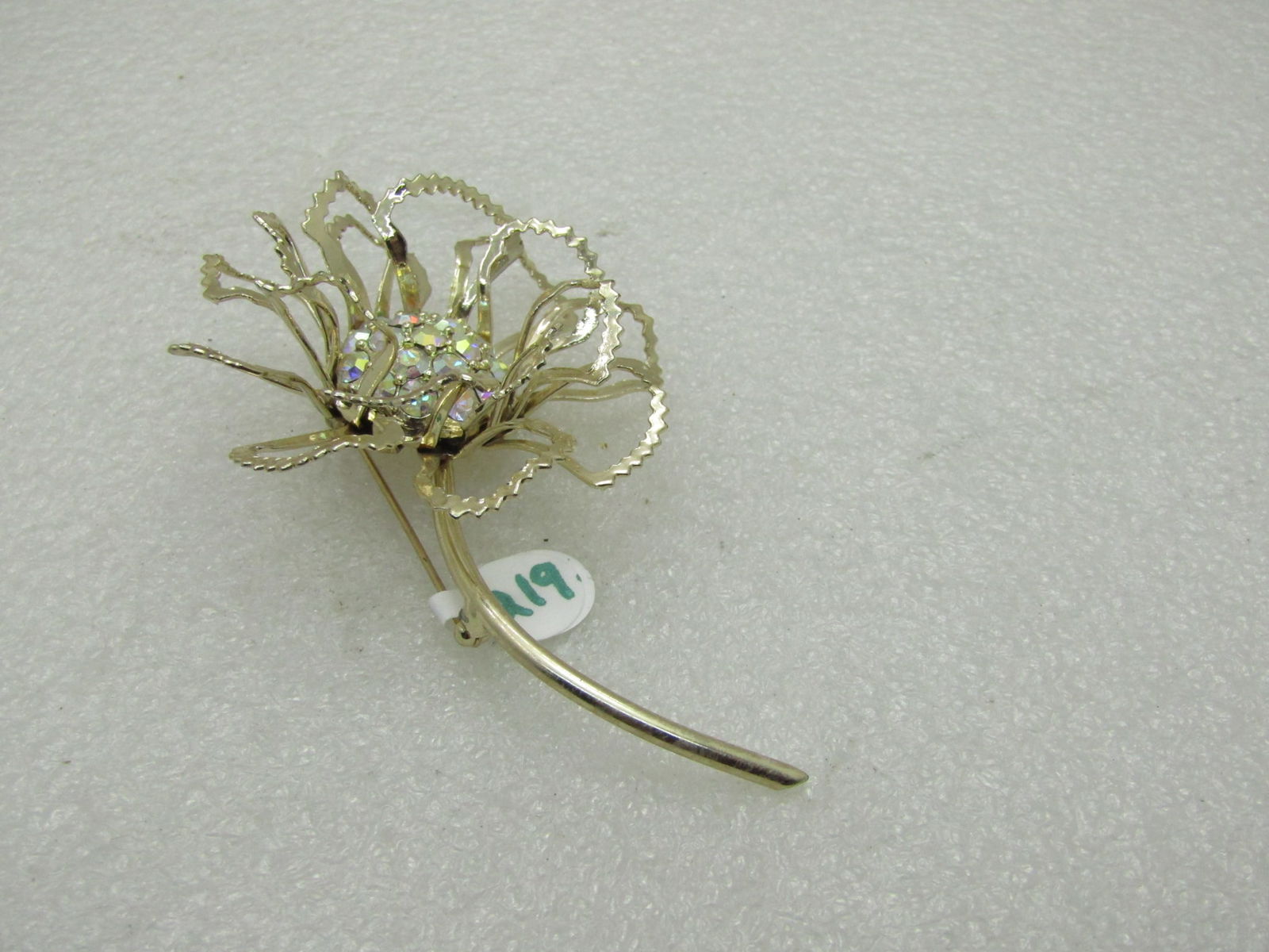 Vintage Sarah Coventry Illusion Floral Brooch: Vintage Sarah Coventry Floral Brooch - over 3.5" tall and 2.25" wide with aurora borealis rhinestone center that is set deep in the center . This has textured accents around the tips of the open frame