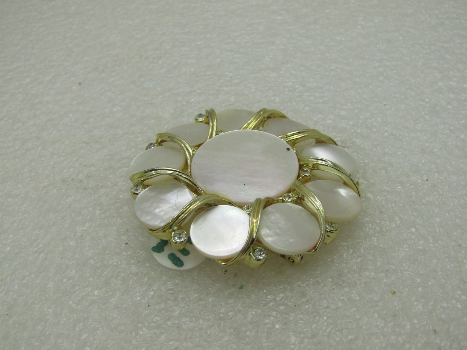 Vintage Mother-of-Pearl Spiral Circle Brooch, 1.5', Mid-Century: Vintage Mother-of-Pearl Spiral Circle Brooch, 1.5', Mid-Century, Gold tone with a 3/4" center mother of pearl disc and 9 smaller discs around the center. Good to very good condition. (WA111020.6 SS422