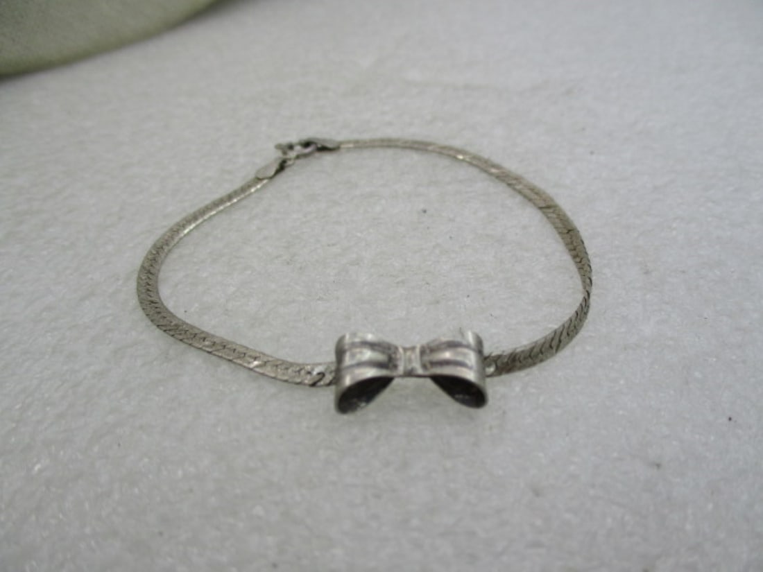 Vintage Sterling Herringbone Bow Bracelet, 7" (LET): Vintage Sterling Herringbone Bow Bracelet, 7", 2.70 gr. The Diamond cut herringbone bracelet is appx. 2.5mm wide and the box that sits on top center is a 3-D looped and ridiged bow that is appx. 5.4mm