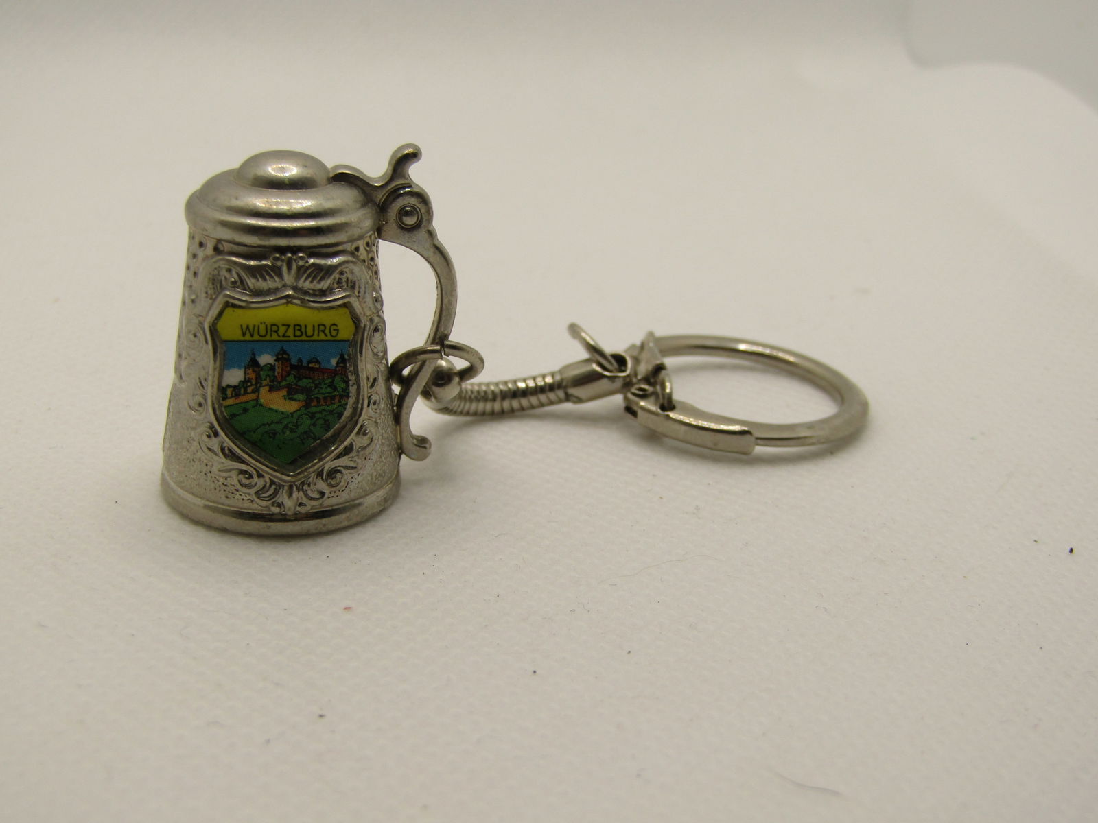 Vintage Wurzburg Germany Beer Stein Key Chain, Souvenir: Vintage Wurzburg Germany Beer Stein Chain, Souvenir. Silver tone key ring with snake chain and an app. 1-1/8" tall beer stein with lid and handle and an enameled Wurzburg shield on the front. Very goo