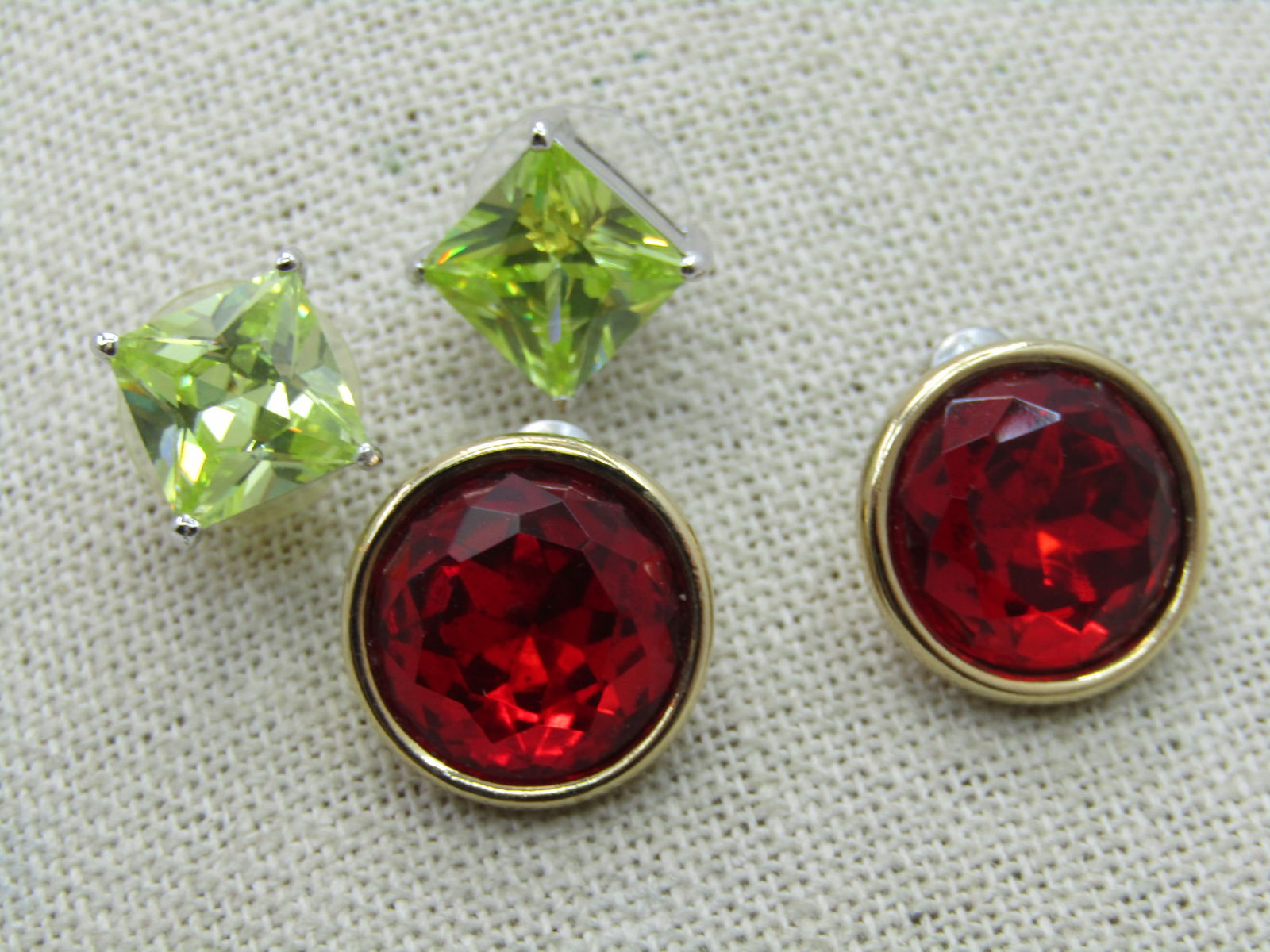 Two Pair, Green CZ & Red Rhinestone Earrings, Pierced Studs: Two Pair, Green CZ & Red Rhinestone Earrings, Pierced Studs. 9,5mm square yellow/green square cz earrings set in square bright silver tone setting. 14mm deep red rhinestone round bezel-set pierced