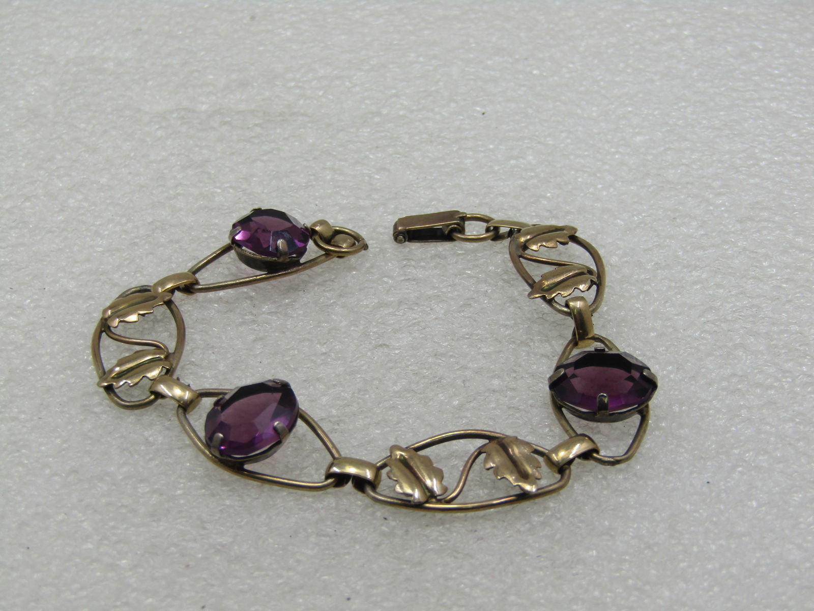 Vintage 12kt GF Purple Rhinestone Leaf Bracelet, 7.25", 1940's: Vintage 12kt GF Purple Rhinestone Leaf Bracelet, 7.25", 1940's. Six 1" by 1/2" cateye shaped open links with an 11.5mm by 10mm oval purple rhinetone in three links that alternate with links that have