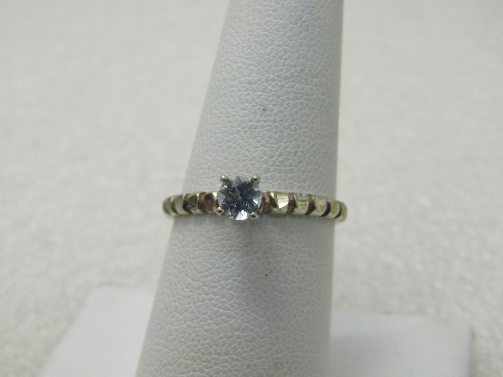 Vintage Blue Topaz Solitaire Ring, Sz. 8, Notched Band: Vintage Blue Topaz Solitaire Ring, Sz. 8, Notched Band, .25 CT blue topaz round cut stone. Sits high on the finger and set with four prongs. The band on either side has diamond cut notches that give t