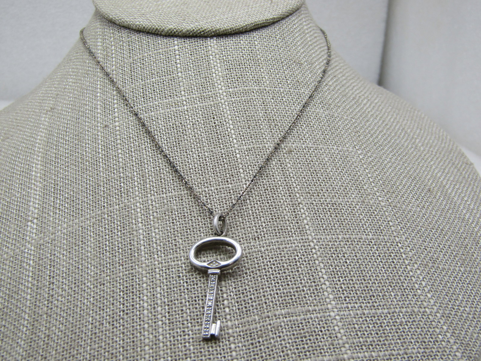 Vintage Sterling Key Necklace, Diamonds, 19" Signed: Vintage Sterling Key Necklace, Diamonds, 19" Signed. Slightly over 1.25" with bail and 1/2" wide the key has small diamonds set down the key and at the base of the oval. It is signed with what looks l