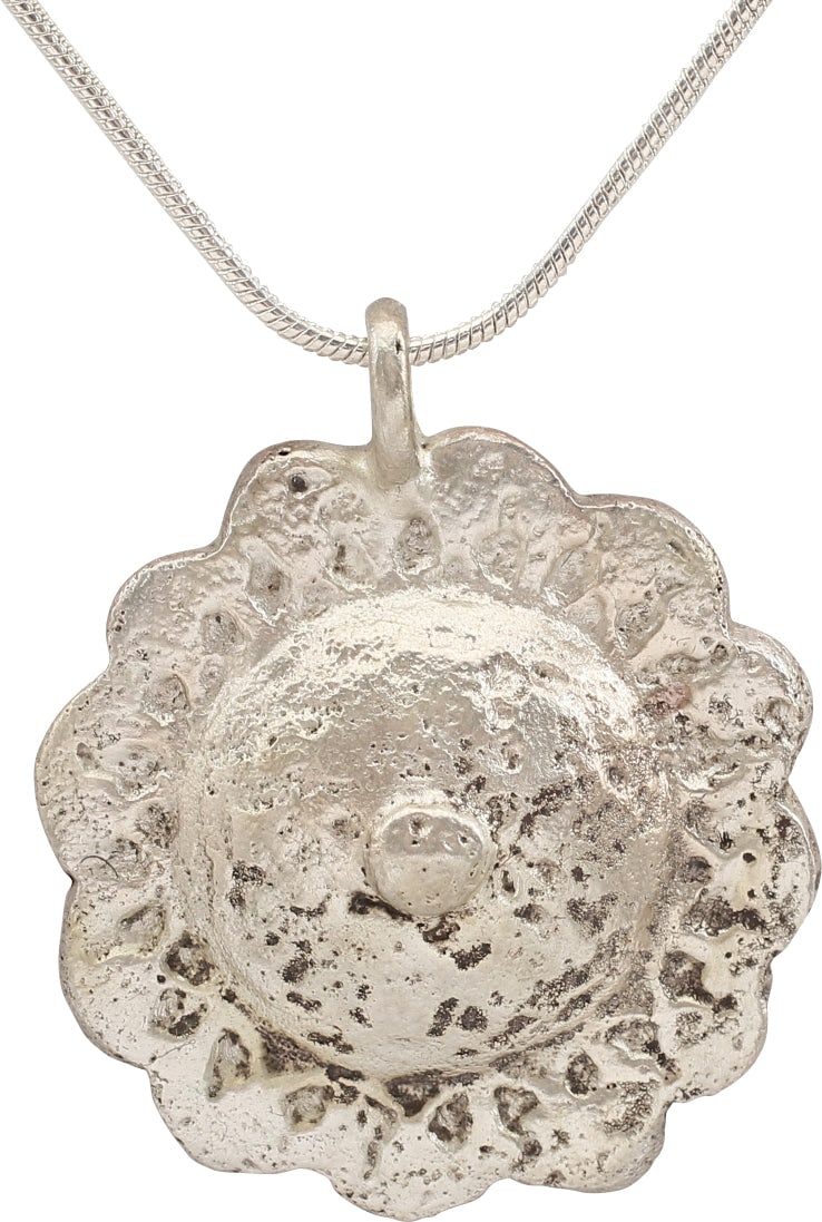 ROMAN WHEEL OF FORTUNE PENDANT NECKLACE.: Late Roman/Byzantine period, 5th-8th century AD. Circular, just under 1 1/4" diameter. Domed with high relief central wheel motif with a central hub and 12 spokes flanking scallops on the perimeter. A