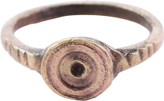 ROMAN EVIL EYE AMULETIC RING 100-350 AD, SIZE 1 3/4: Gilt bronze. Size 1 ¾ for wear on the small finger between the first two joints as was the custom. Rounded face band 1.3mm width with hatched shoulders. Round bezel, the face with relief concentr
