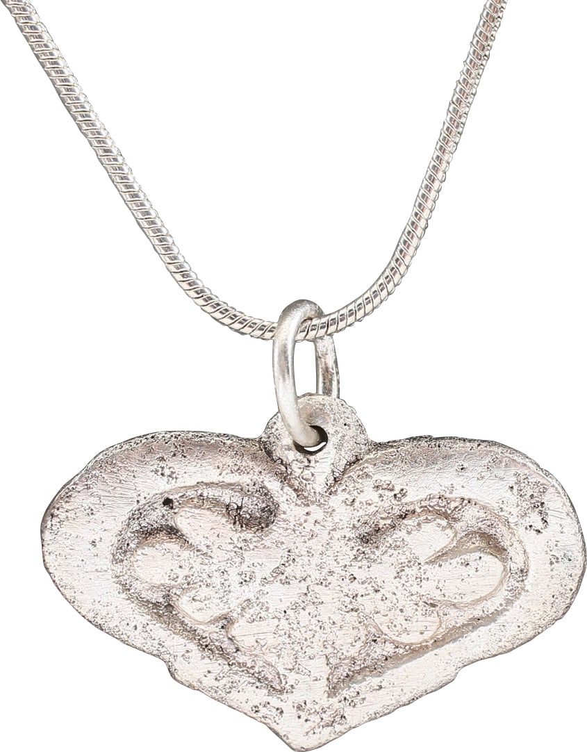 VIKING HEART PENDANT NECKLACE C.950-1050 AD: Silvered bronze, just over 1" width. The heart in its fully developed form with a cusped top, broad borders, and a field with a raised trefoil which was a favorite Viking decorative element. Relativel