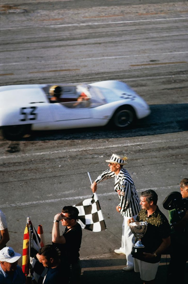 Slim Aarons Official Estate Print - Checkered Flag - Oversize: 1963 (Printed later): Title: Slim Aarons Official Estate Print - Checkered Flag - Oversize: 1963 (Printed later) Description: Checkered Flag The checkered flag signals the end of the race during the 1963 Nassau Speed Week.