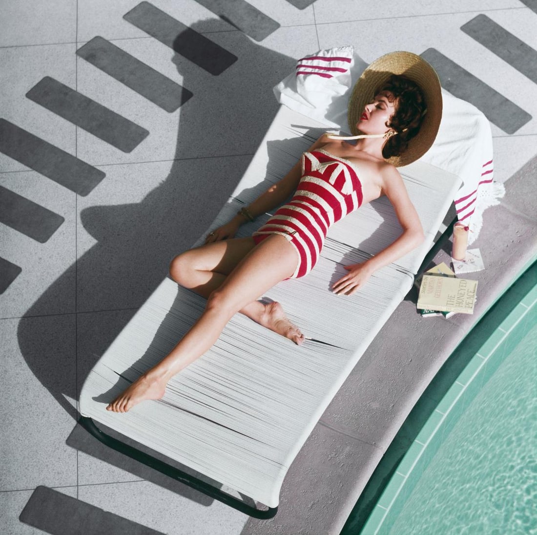 Slim Aarons Official Estate Print - Mara Lane At The Sands - Oversize: 1954 (Printed later): Title: Slim Aarons Official Estate Print - Mara Lane At The Sands - Oversize: 1954 (Printed later) Description: Mara Lane At The Sands Austrian actress Mara Lane lounging by the pool in a red and