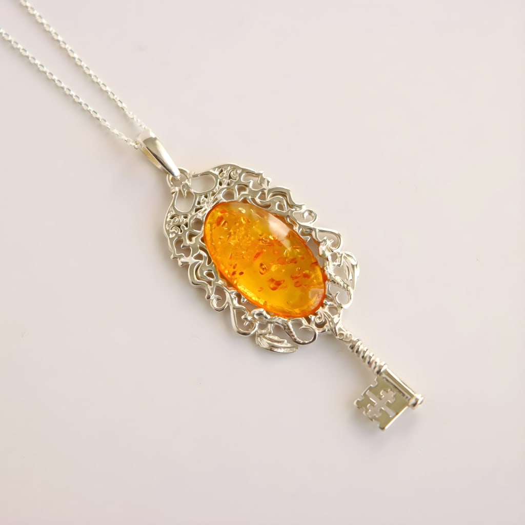 Baltic Amber Key Pendant Necklace in Sterling Silver: Title:Baltic Amber Key Pendant Necklace in Sterling SilverDescription:This amber necklace features a gothic key pendant crafted in solid 925 sterling silver and set with bright Baltic lemon amber.
