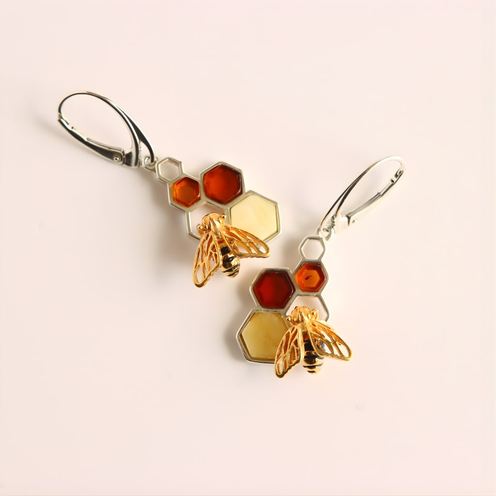 Gold Bee Honeycomb Amber Earrings - Sterling Silver: Title:Gold Bee Honeycomb Amber Earrings - Sterling SilverDescription:These amber earrings feature a clean honeycomb design accented with a small gold bee and three genuine amber gemstones.