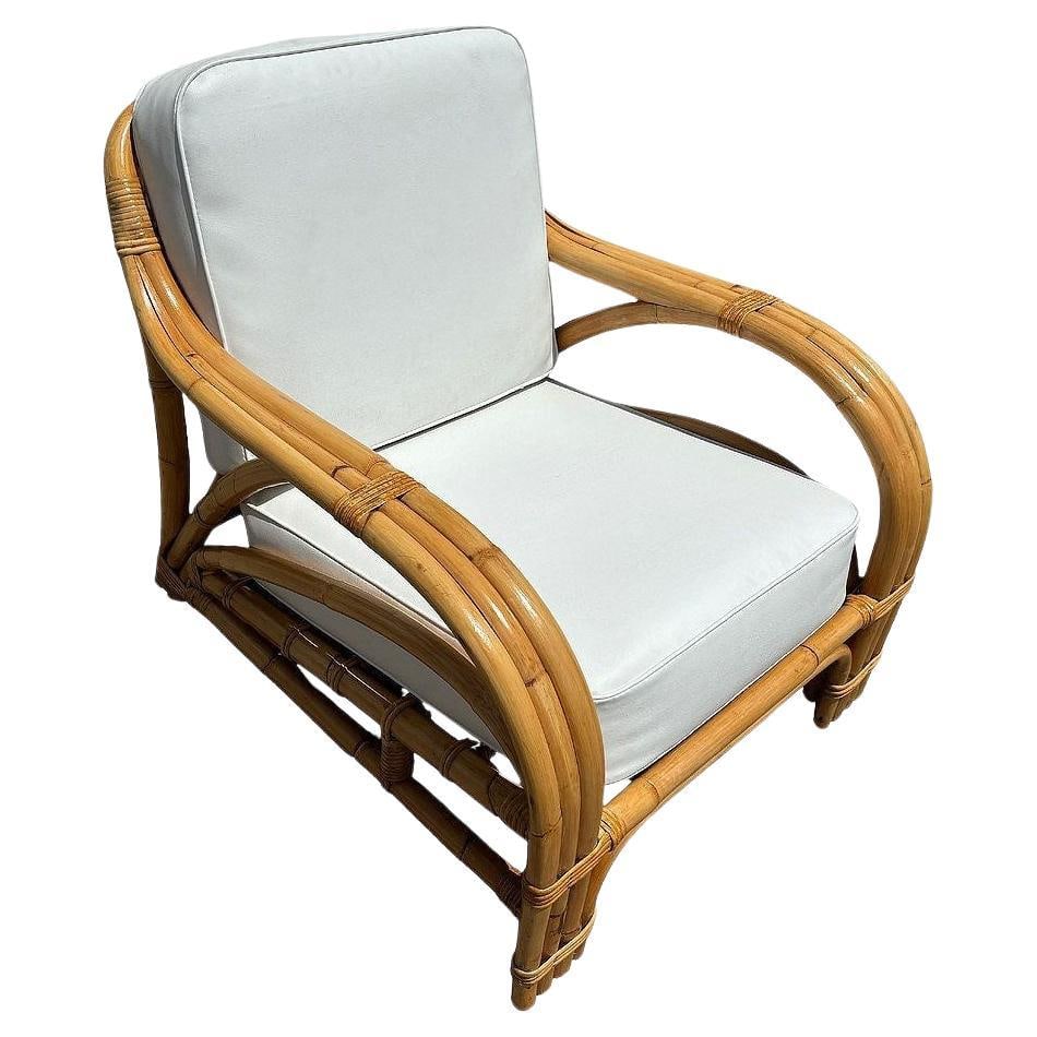 Restored Mid-century Rattan 3 Strand Transitional Lounge Chair: The Restored Rattan 3 Strand Transition Lounge Chair features a sleek, mid-century design with a handwoven three-strand rattan frame. Meticulously restored, it offers a blend of modern design and trop