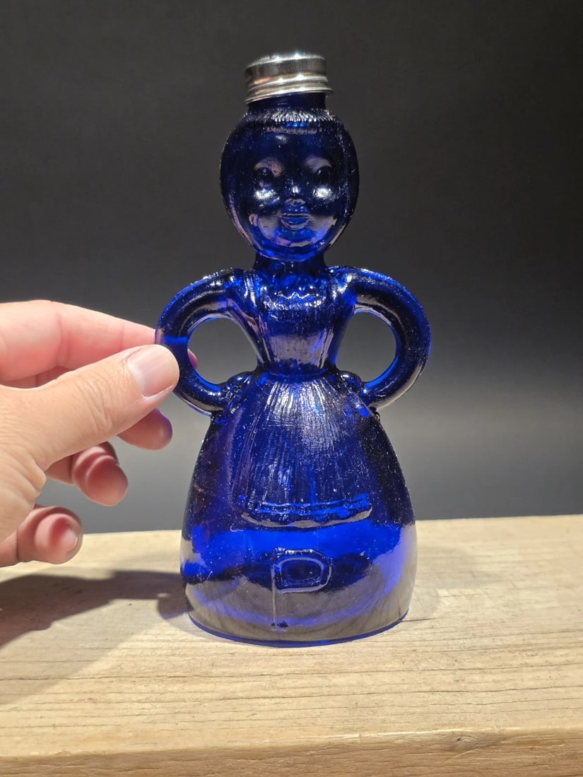 7" Cobalt Blue Depression Glass Lady Bottle: Modeled after 1940s Wheaton figural glass bottles, this mid century reproduction cobalt-blue design echoes the decorative perfume and syrup containers once found in mid-century American homes. Its