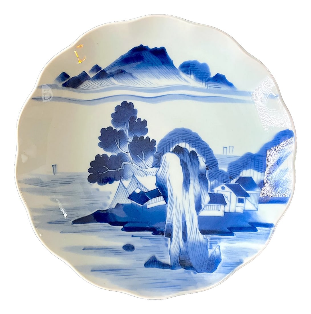 Mid 20th Century Japanese Arita Blue & White Landscape Plate, 12" Diameter "” Ming: This hand-painted blue-and-white porcelain plate features a tranquil village landscape beneath rolling mountains, rendered in soft cobalt underglaze. The painter's brushwork evokes the serene rhythm a